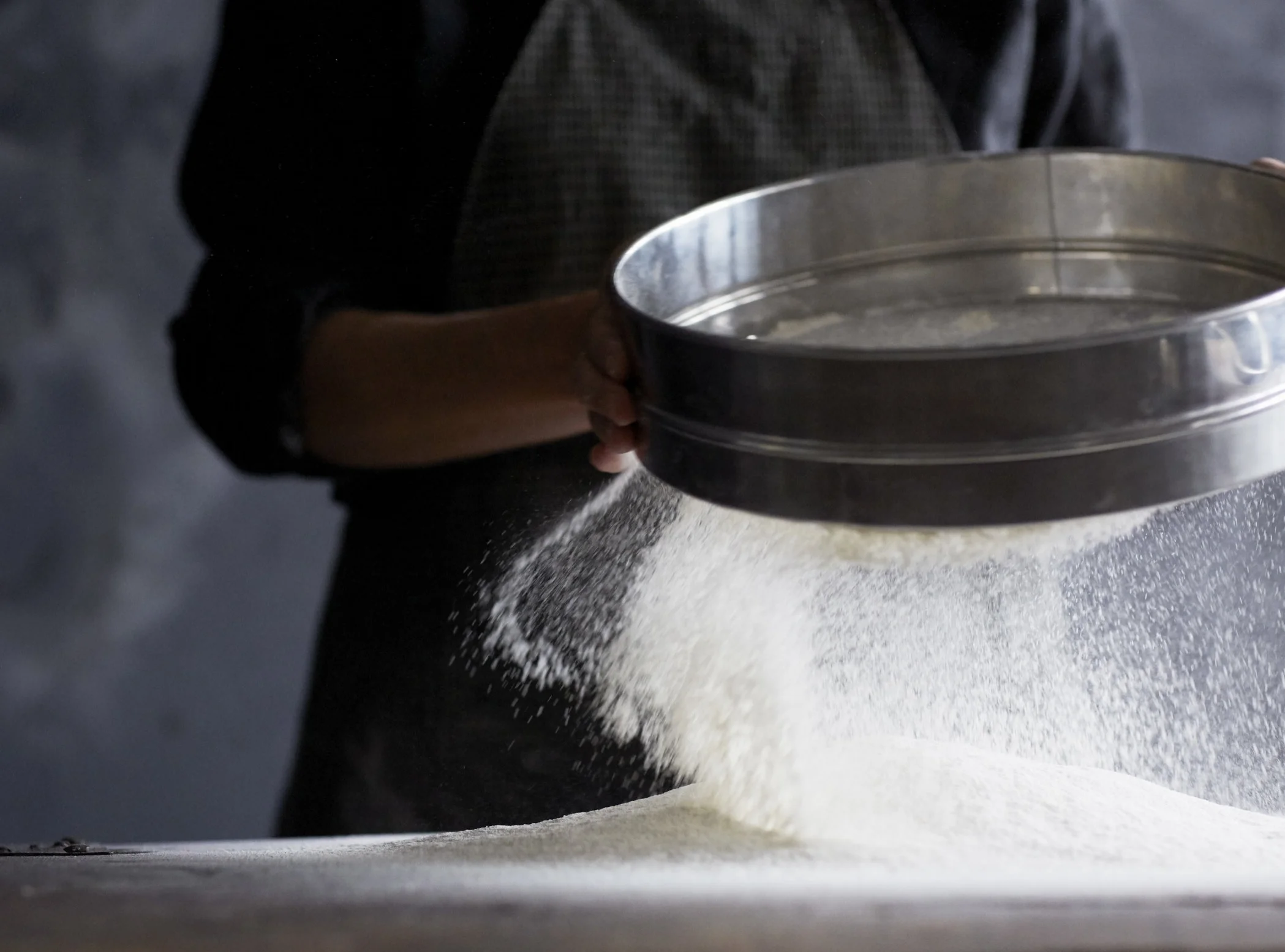 Baker sifting flour