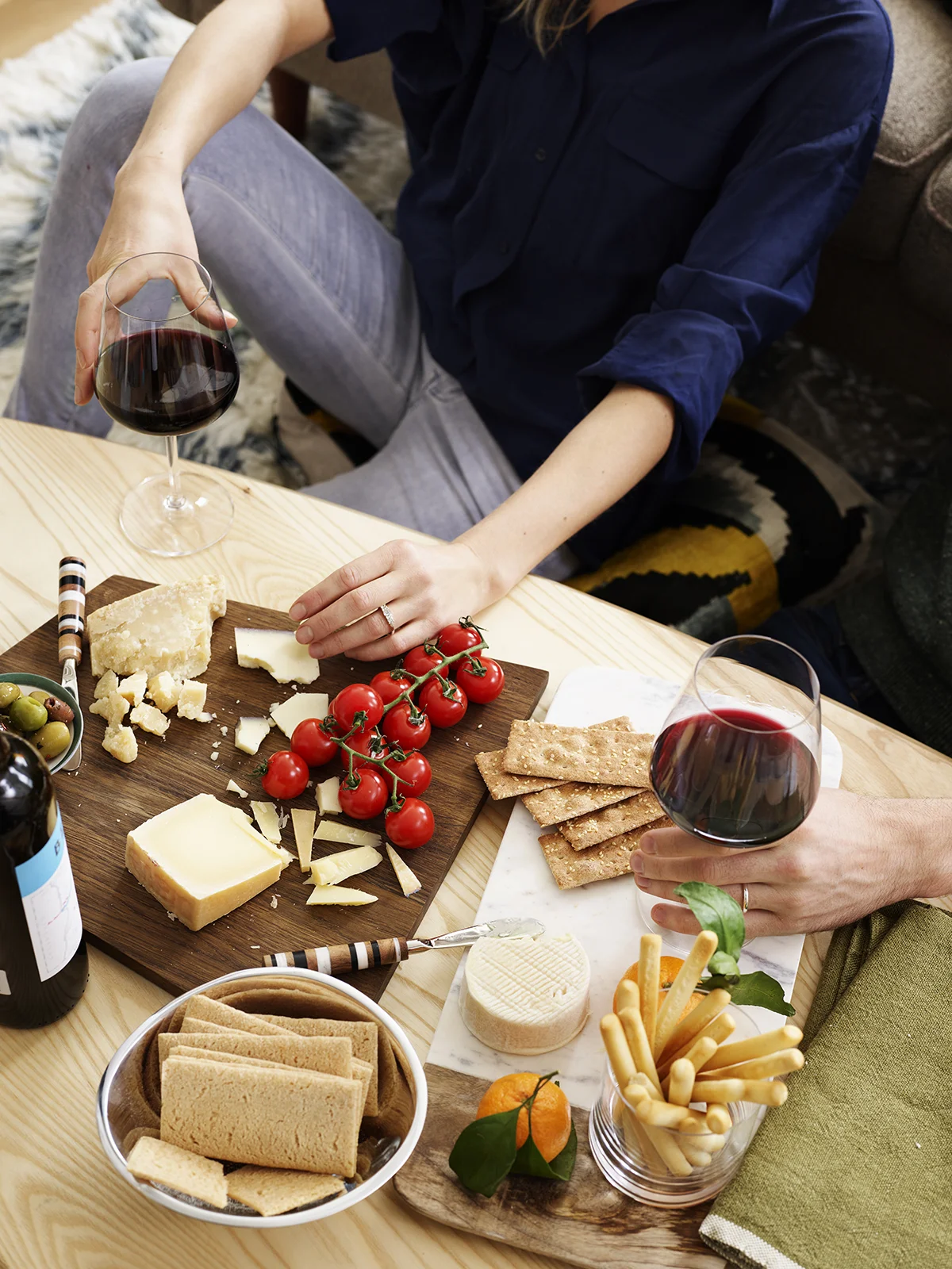 Couple eating cheese and crackers and drinking wine