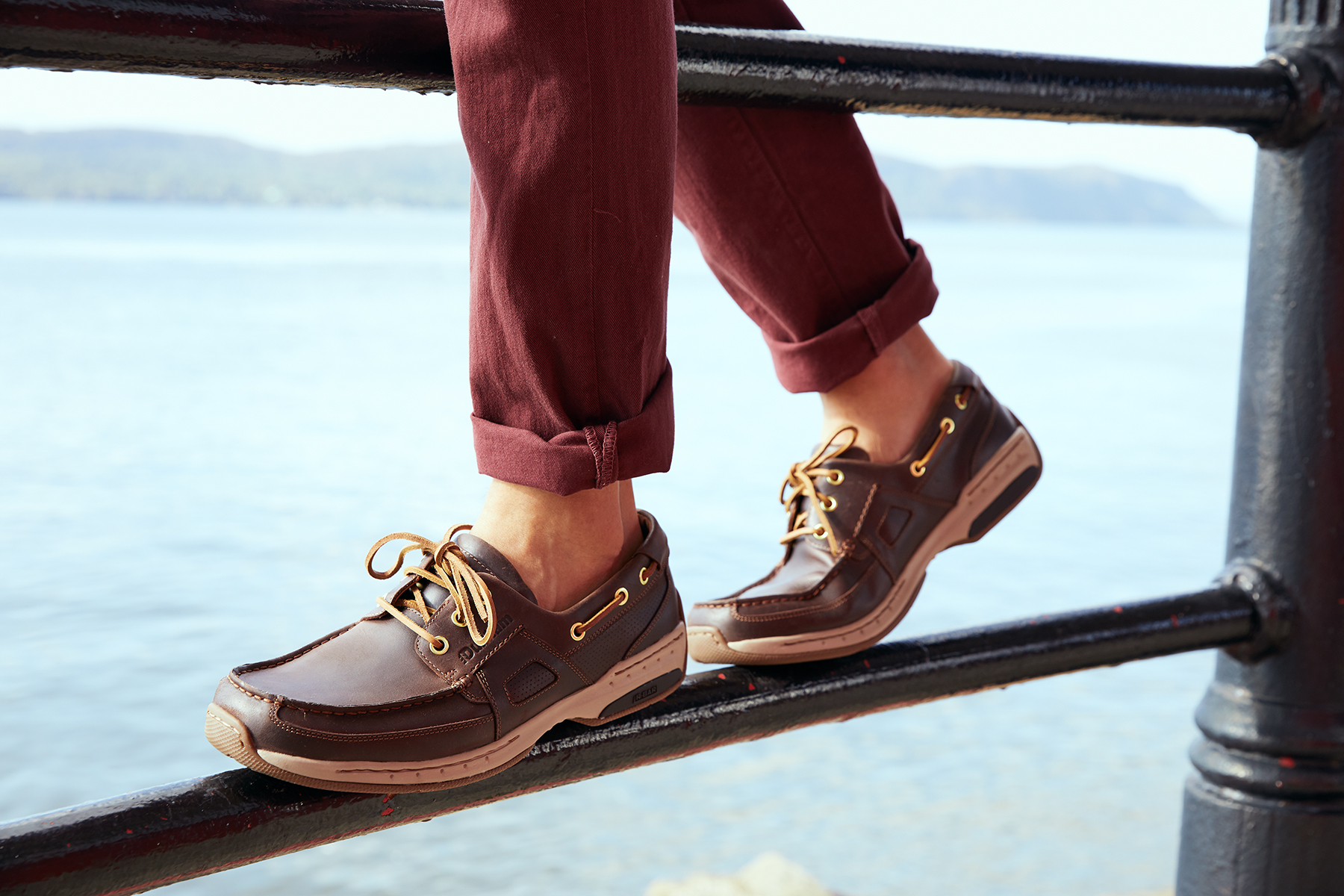 Man standing on railing by river