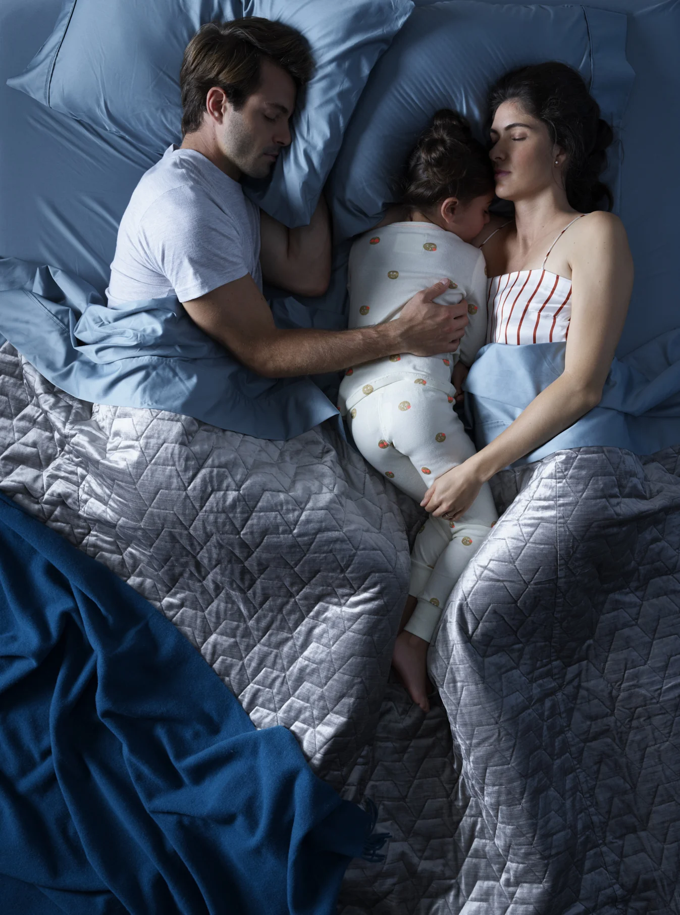 Family sleeping in bed