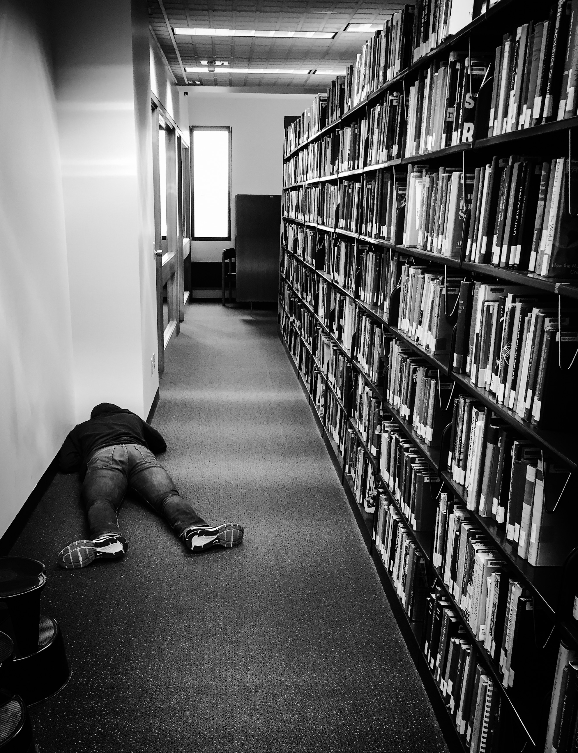 iPhone photo of a student sleeping at the Wallace Library on the RIT campus.