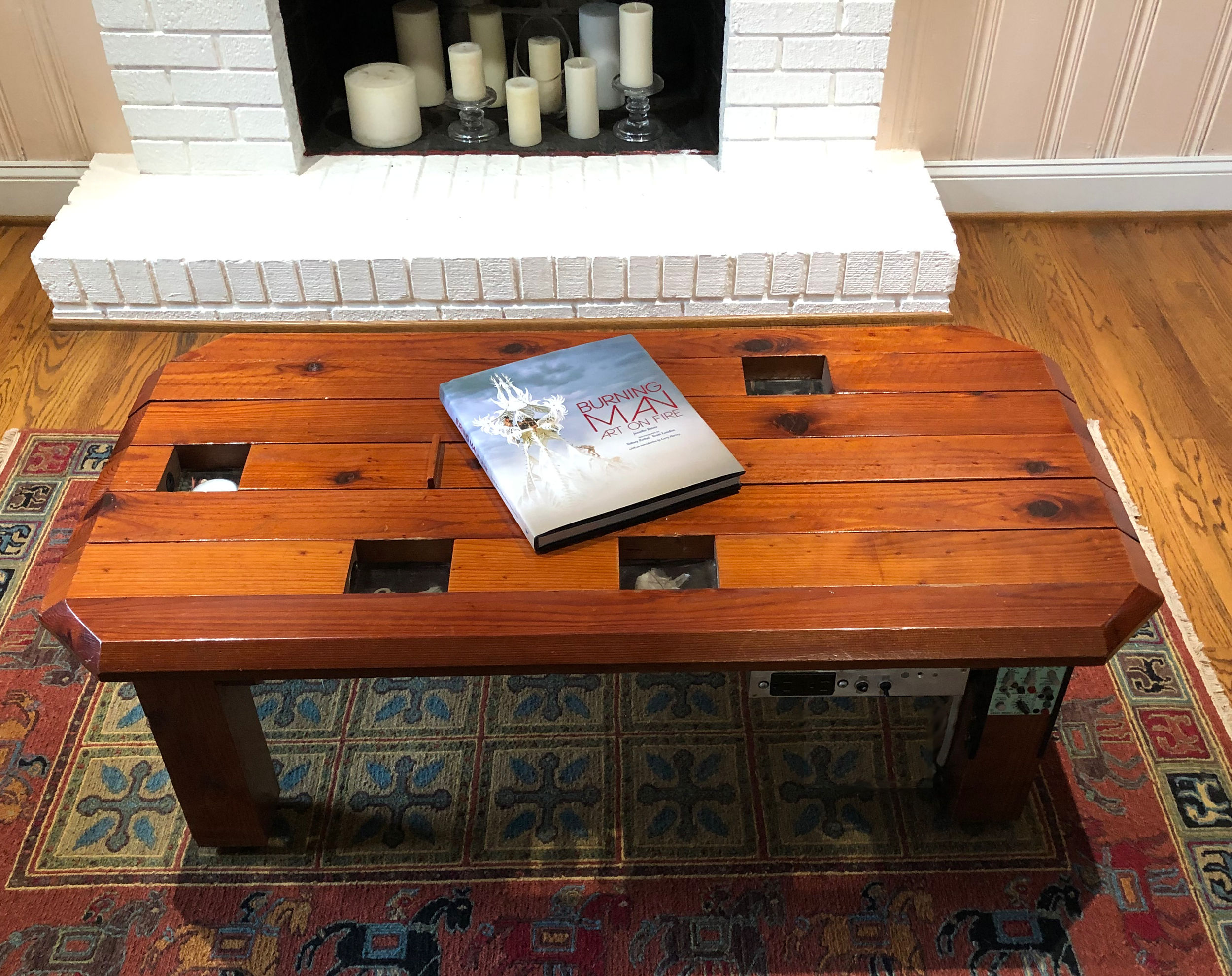 Redwood and electronics coffee table with interrupter switched LED lighting below recessed cup holders and hidden slide storage compartment