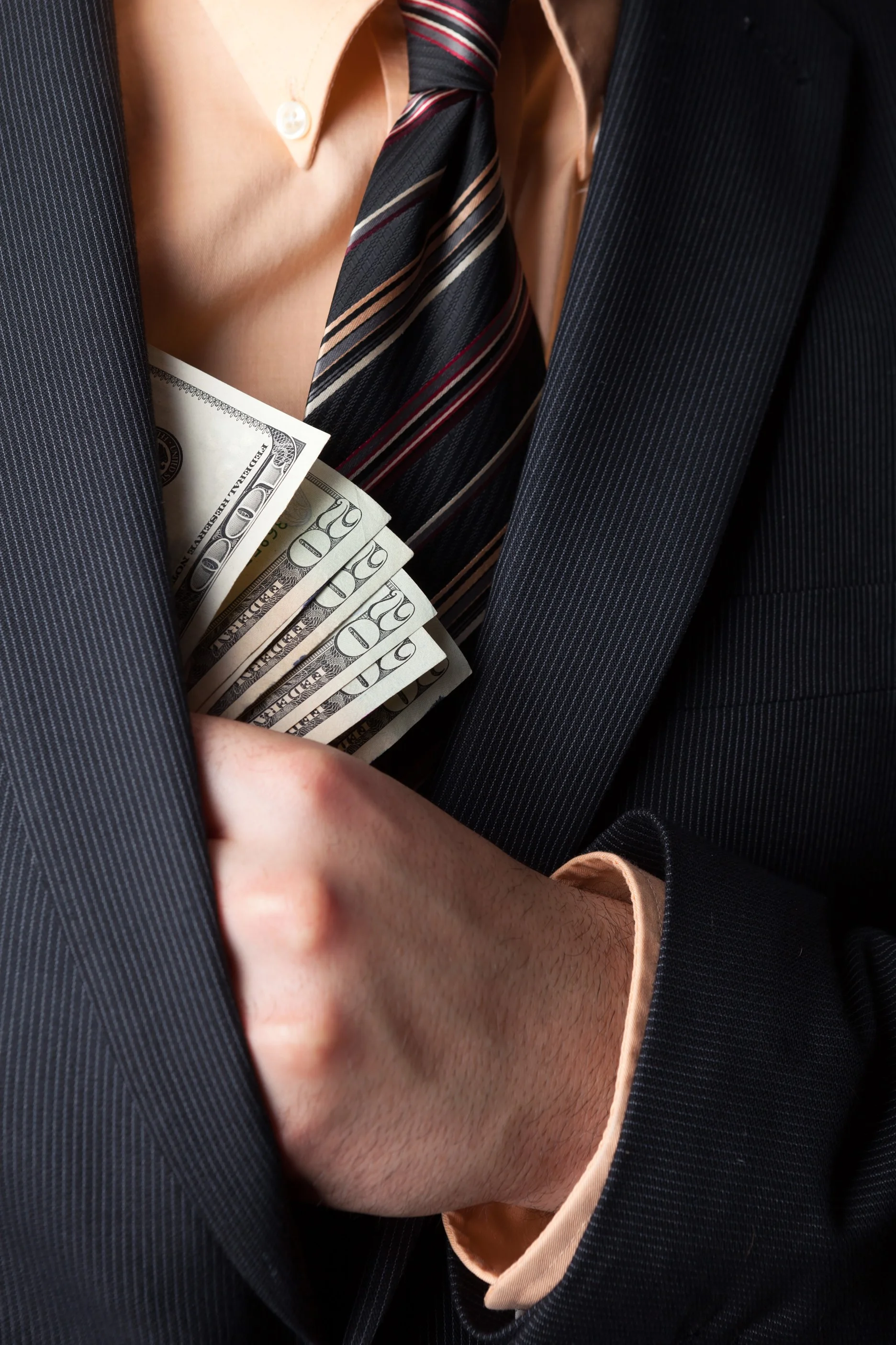 close-up-of-a-business-mans-hand-hiding-money-in-his-suit-jacket-pocket_HtgbyuvCBi-sm.jpg