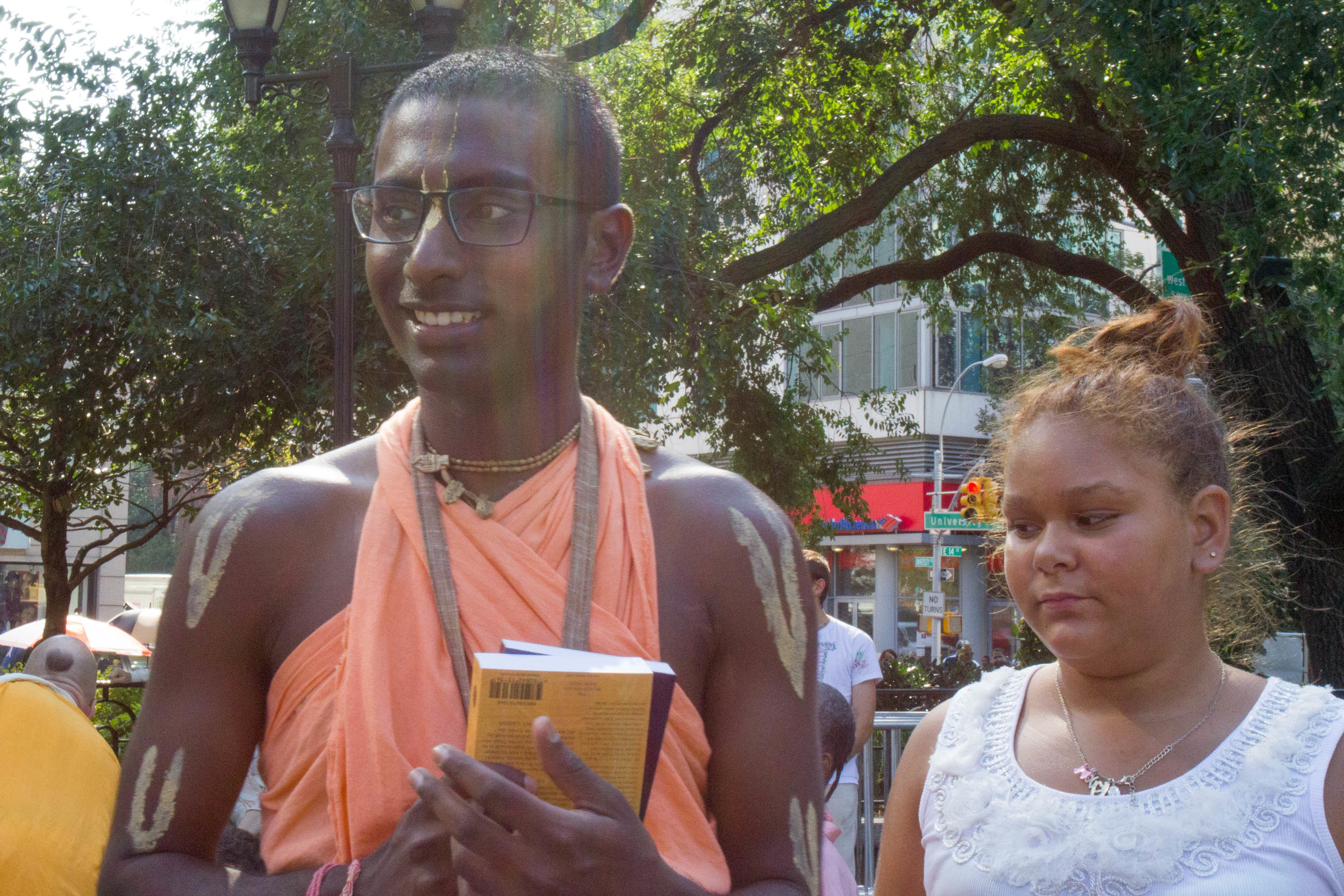 Nihal clasps the Bhagavad Gita, which he tries to distribute to passers-by in exchange for a small donation