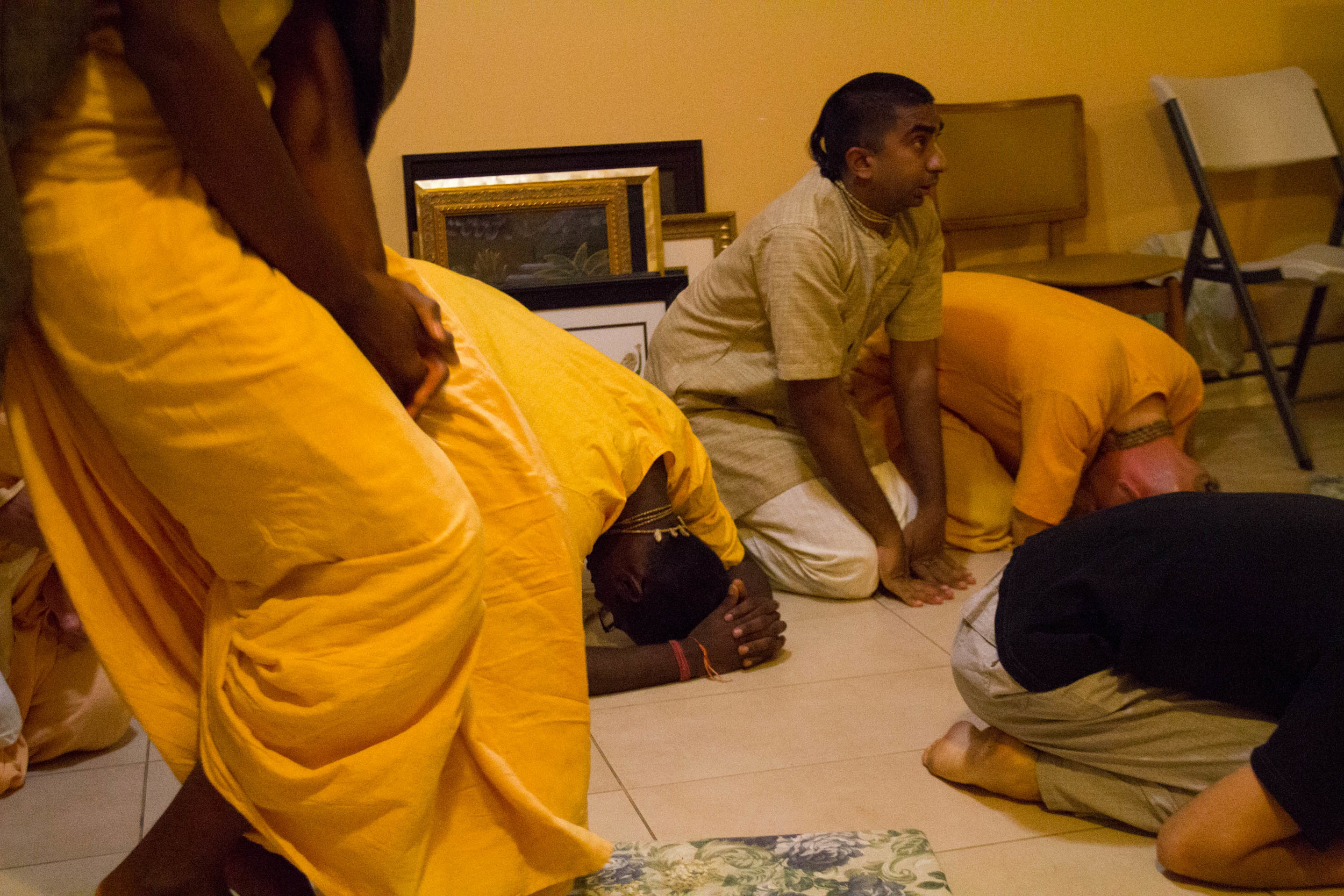 Nihal kneels down to pray during Sunday morning prayers at his communal home in Brooklyn