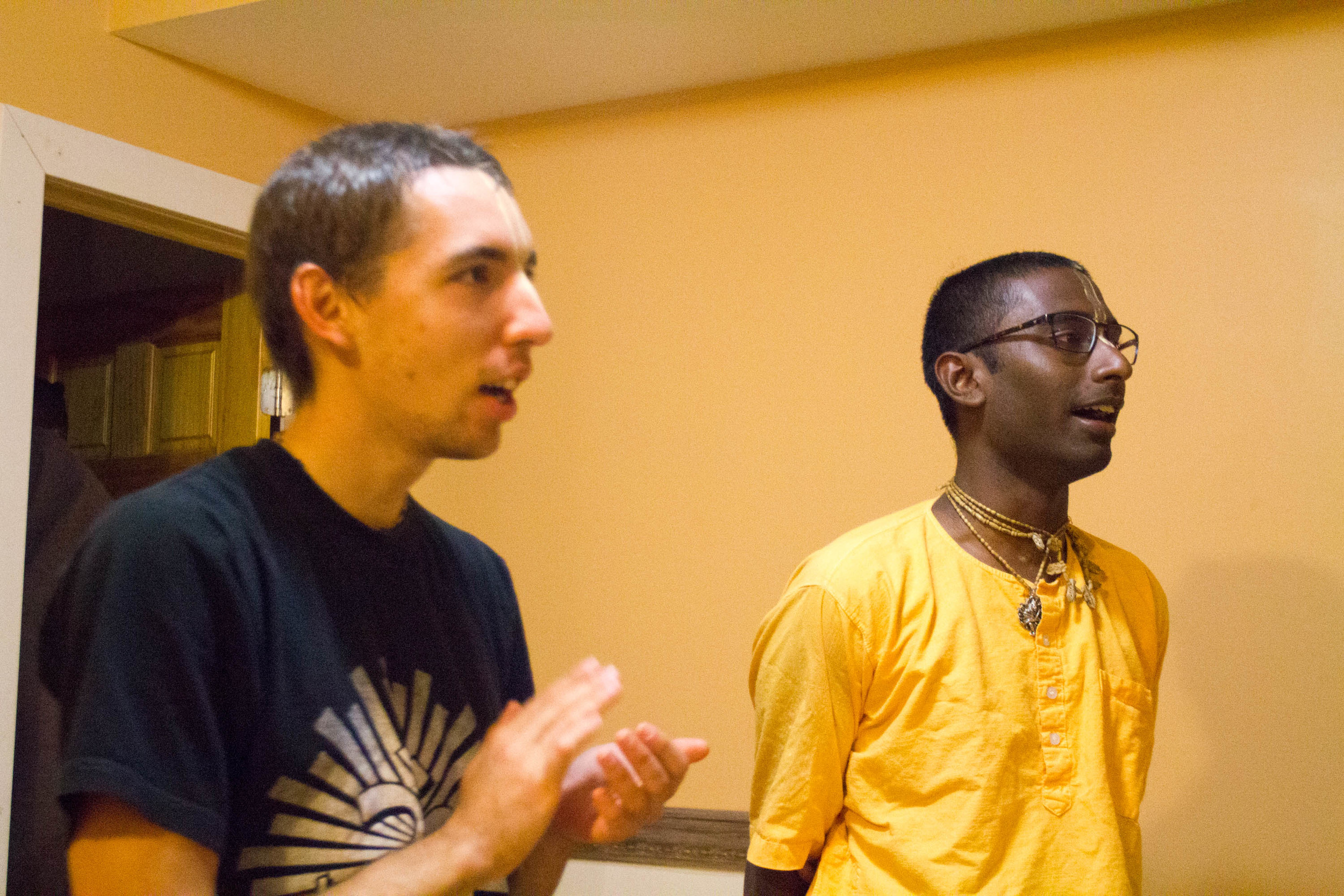 Nihal claps and sings alongside a fellow friend and devotee