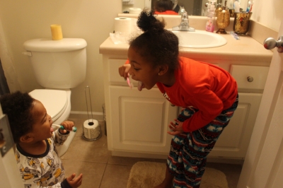 Winnie schooling IV on the art of teeth brushing.