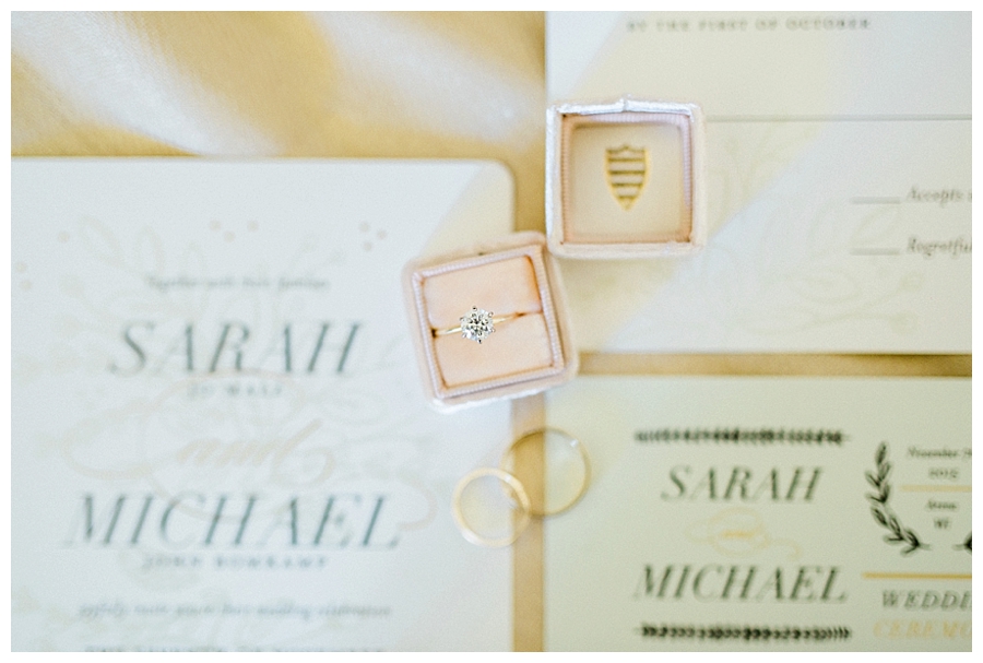 wedding ring in a blush The Mrs. Box atop wedding stationary at a rustic outdoor fall wedding