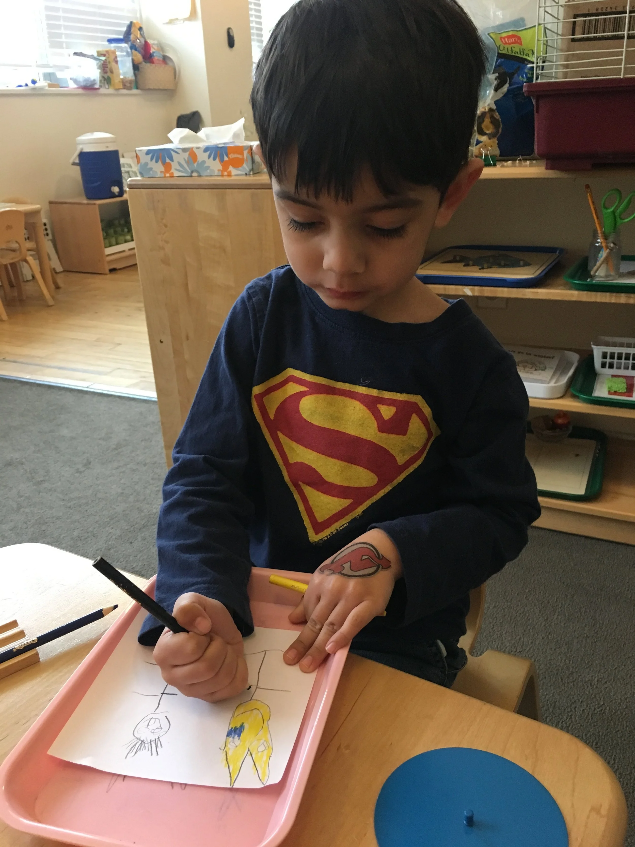 A child draws Batman and the Joker.