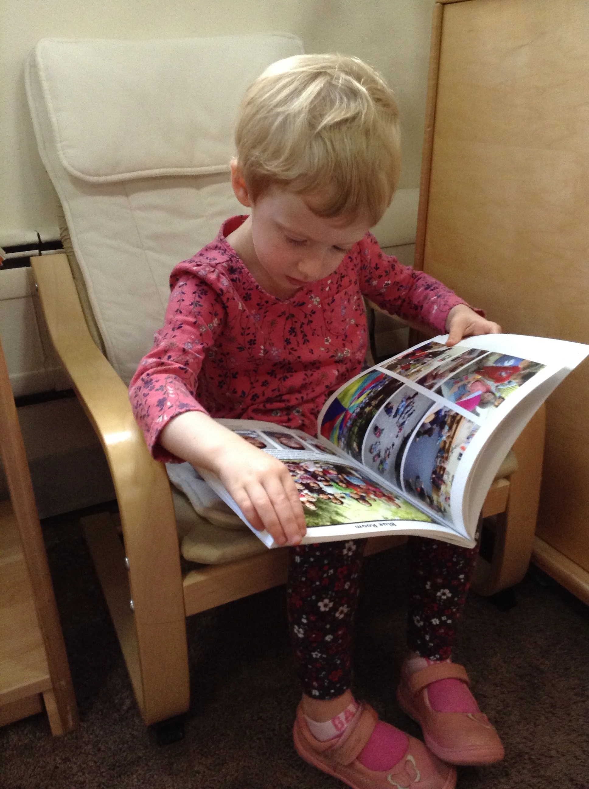 Looking at a picture book in the reading area. 