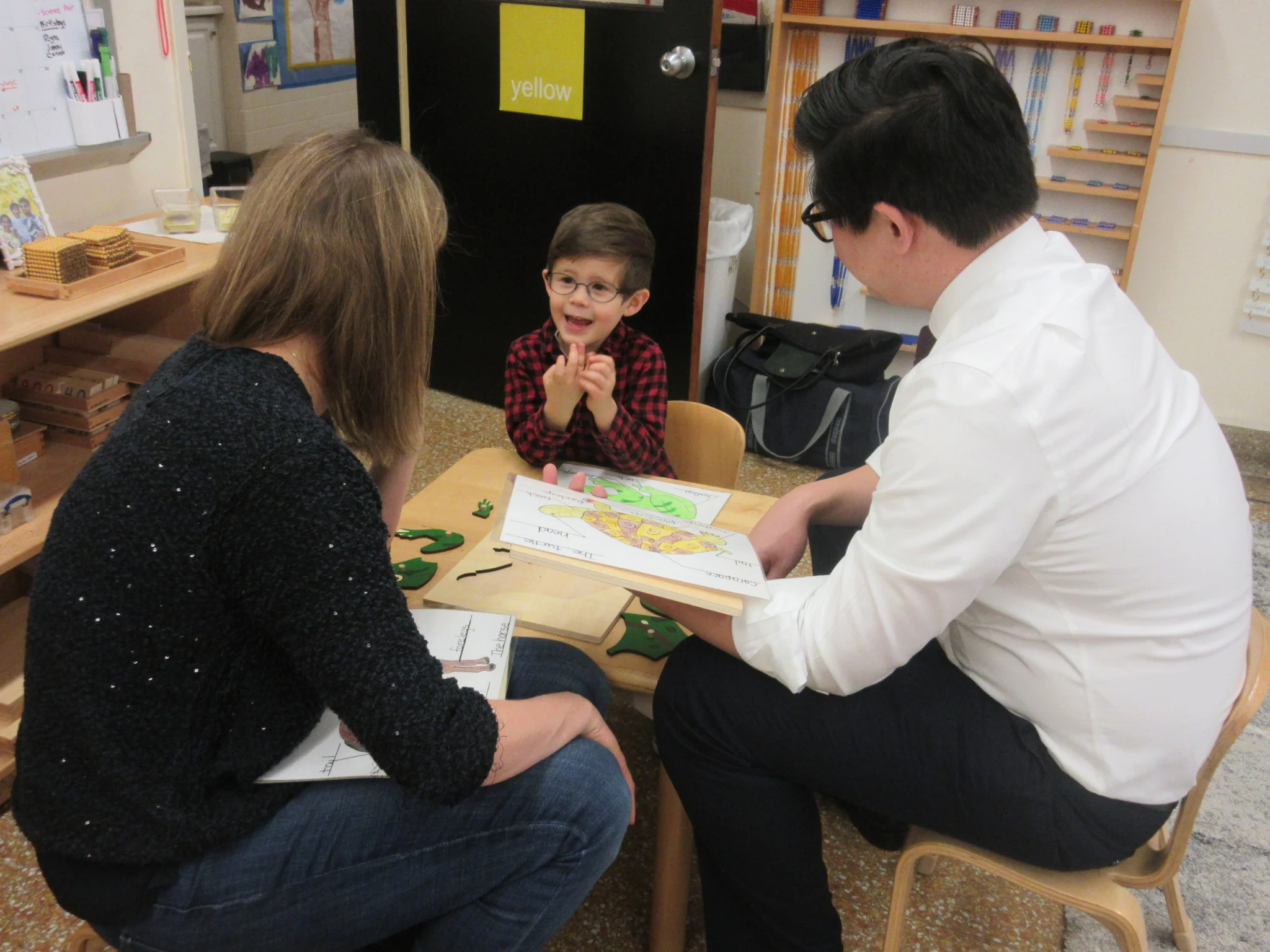 Work with your child week: Showing his favorite frog puzzle work to his mom and dad.