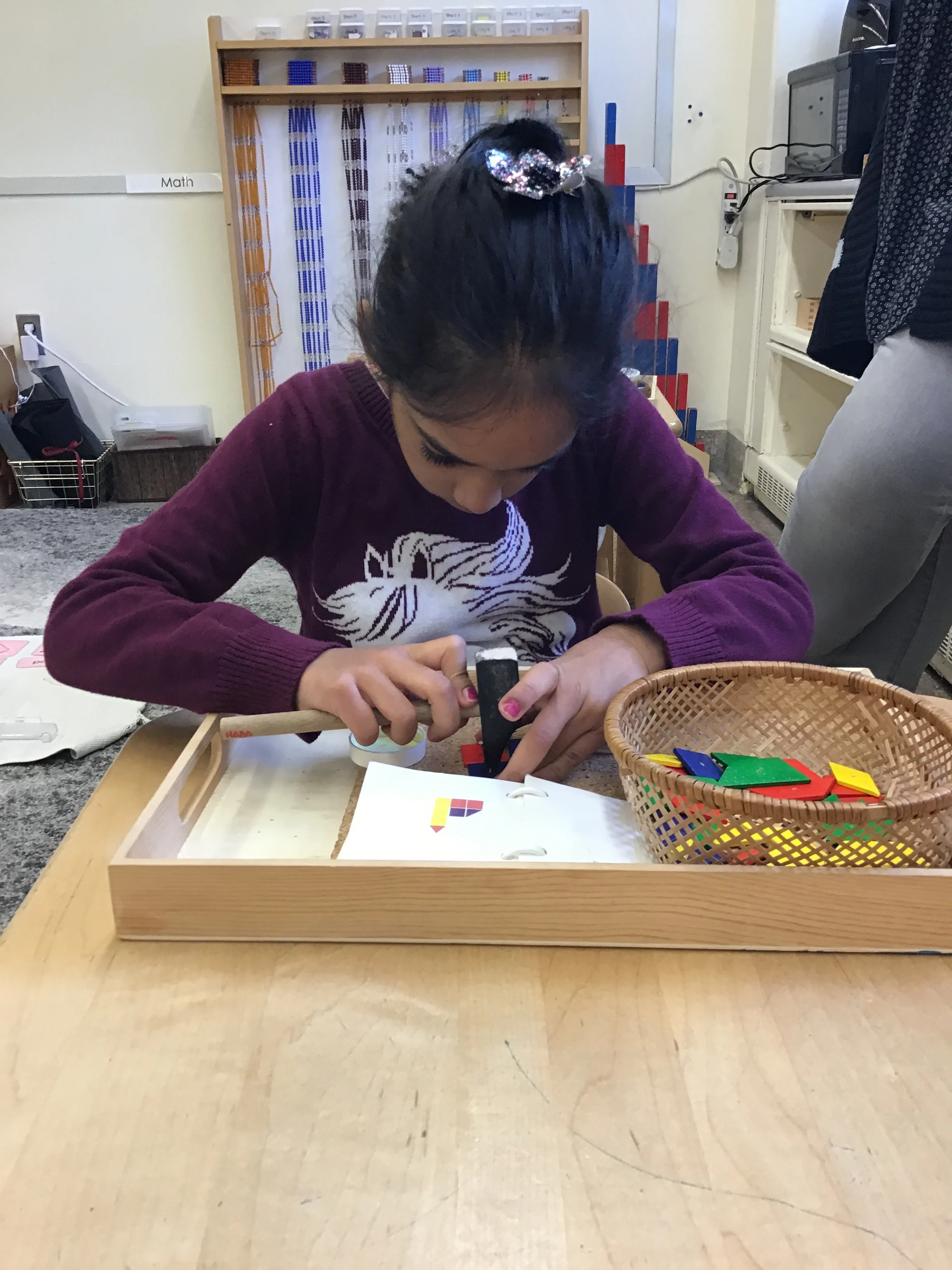 Making patterns with different shapes using tiny nails and a hammer.