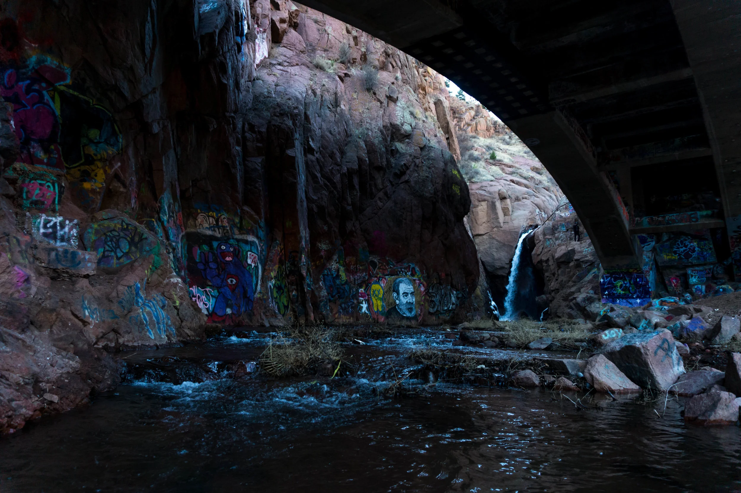 GrafittiFallsunderneaththebridgewithflowingriver.jpg