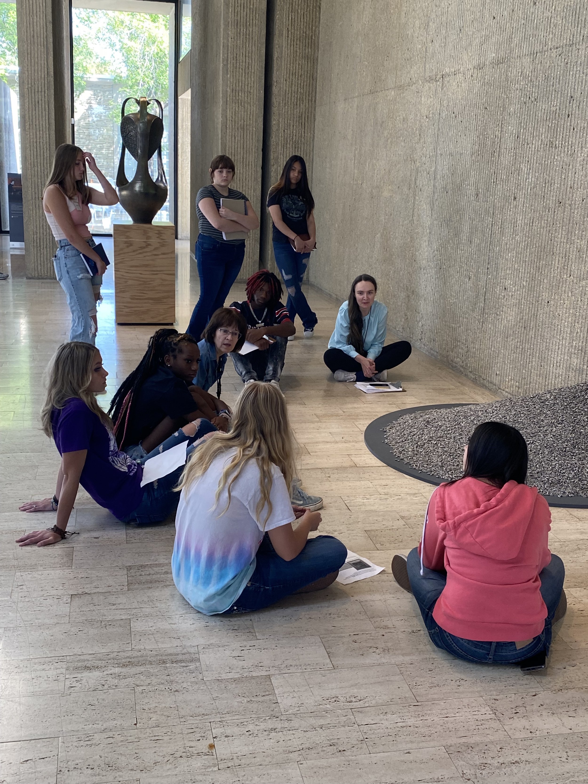 Students sit with and discuss Ai Weiwei's "Sunflower Seeds"