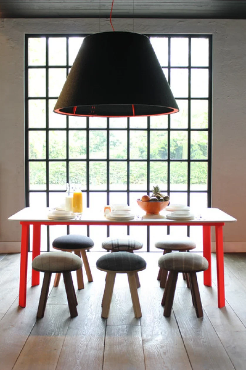 Red stitching on this BuzziShade felt fixture adds a color pop and helps to connect to the bold dining table / Source