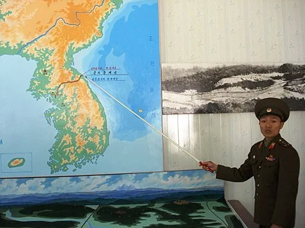 North Korean soldier points to the demilitarized zone between the two Koreas.