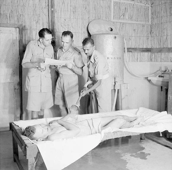 Person being cooled with water spray, one of the treatments of heat stroke in Iraq in 1943