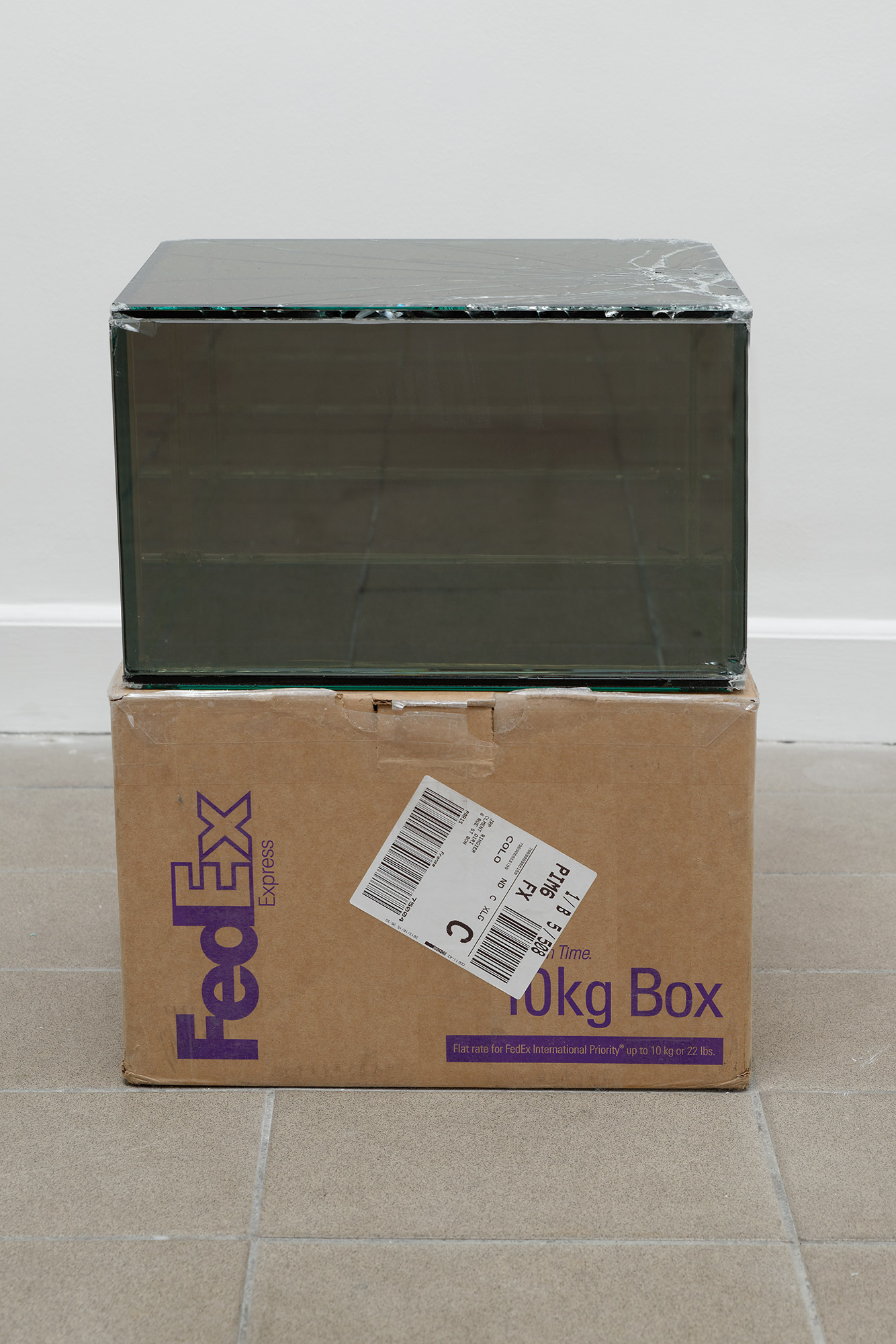   FedEx® 10kg Box  © 2006 FedEx 149801 REV 9/06 MP, International Priority, Los Angeles–Paris trk#796907687919, October 14–16, 2013    2013–   Laminated Mirropane, FedEx shipping box, accrued FedEx shipping and tracking labels, silicone, metal, tape 