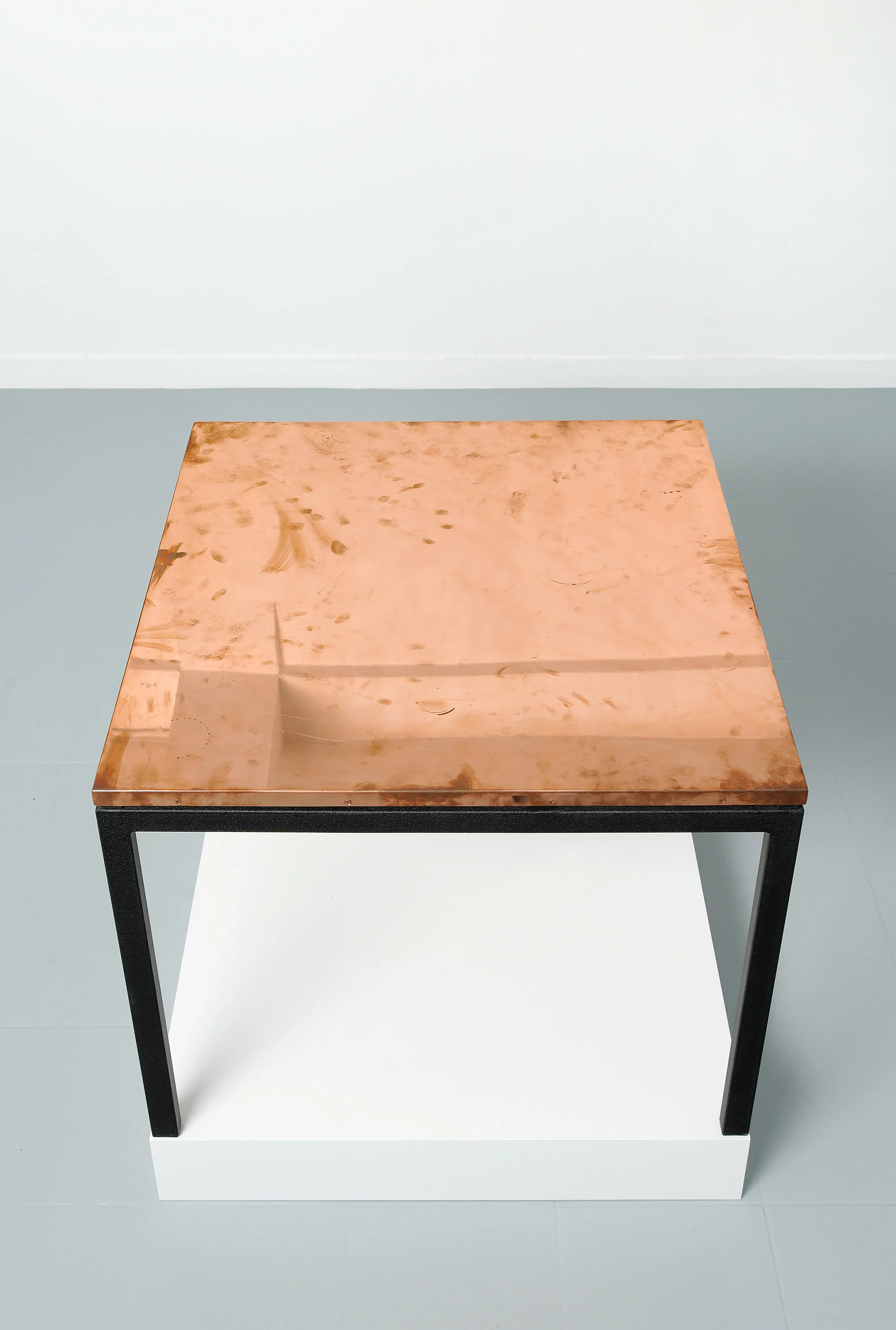 Copper Surrogate (Table: designed by Charlotte Perriand and Le Corbusier, 1959; Galerie Rodolphe Janssen, Brussels, Belgium, August 10th–September 2nd, 2011) Polished copper table top and powder-coat steel 2011 Table: 33 5/8 x 33 5/8 x 1 inches Diapositives, 2011