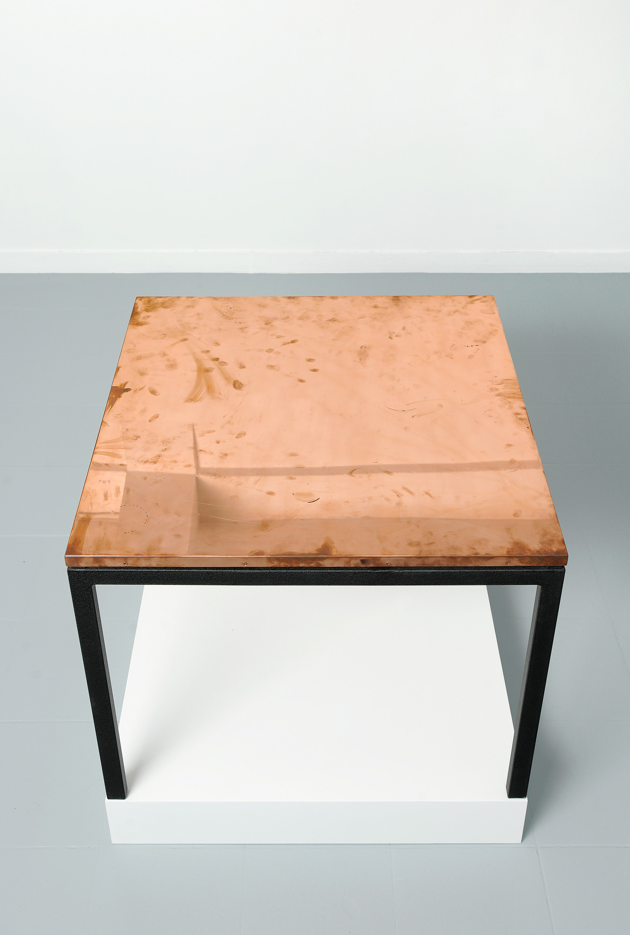   Copper Surrogate (Table: designed by Charlotte Perriand and Le Corbusier, 1959; Galerie Rodolphe Janssen, Brussels, Belgium, August 10th–September 2nd, 2011)   Polished copper table top and powder-coat steel   2011   Table: 33 5/8 x 33 5/8 x 1 inch