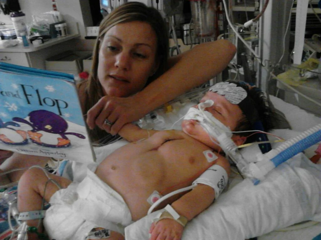 Webb's mother, Kara, reads to him shortly after his open heart surgery in 2012.