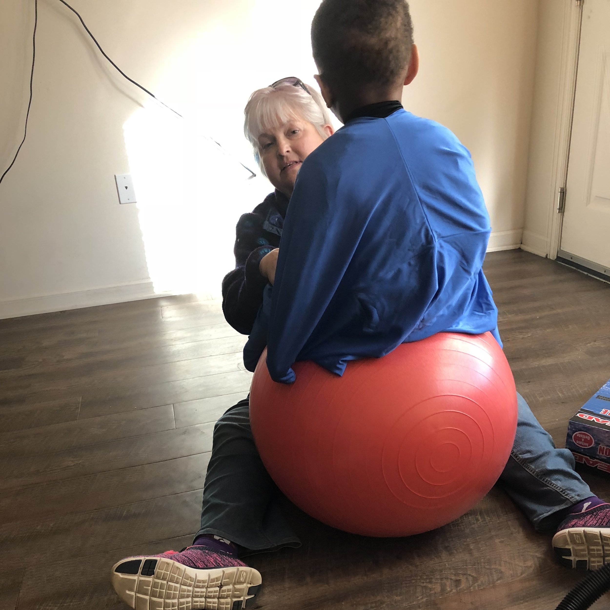  SIre's PT works on his focus while wearing the sensory sack on the yoga ball. 