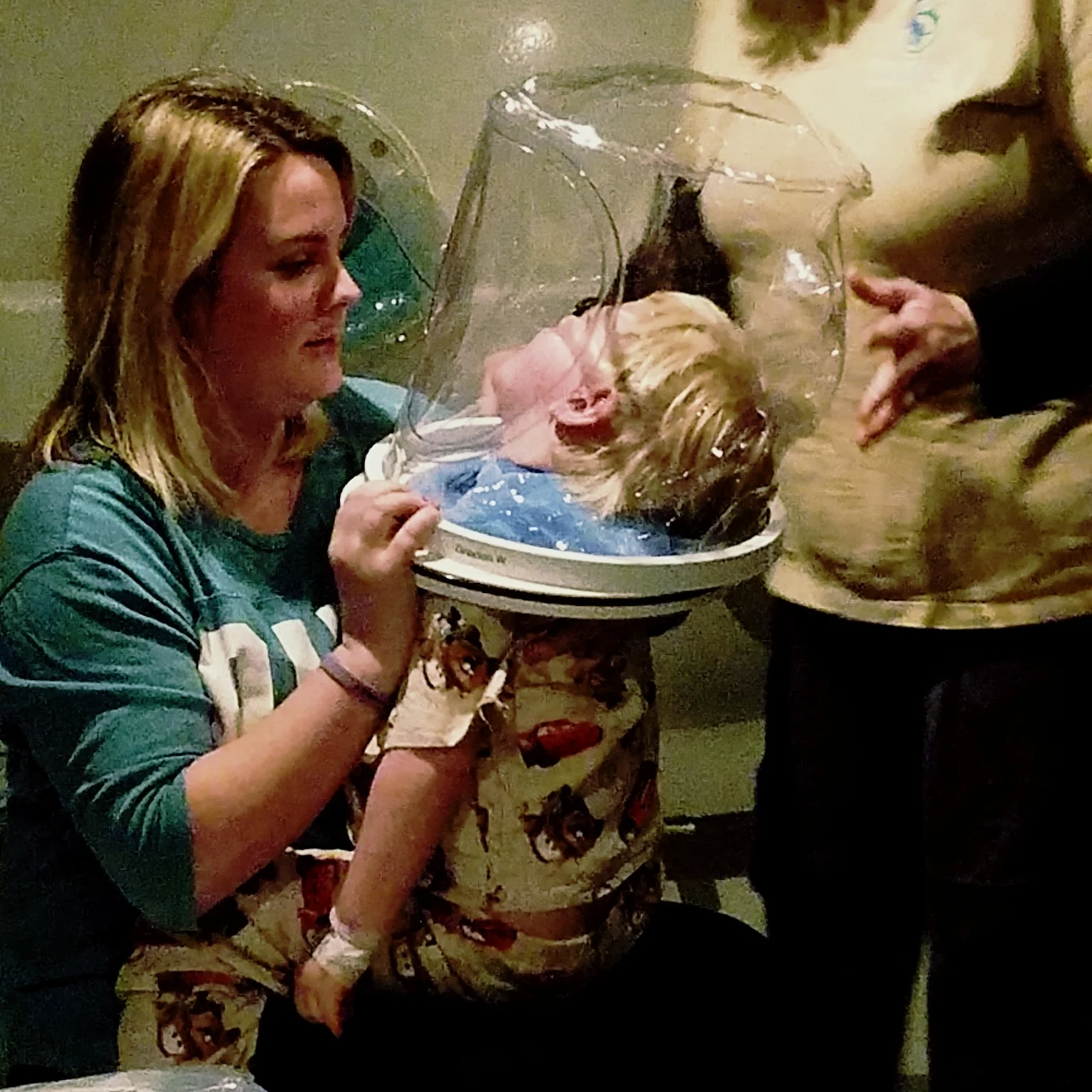 Grayson's mother, Jordan, holds him upright during a hyperbaric chamber therapy dive.