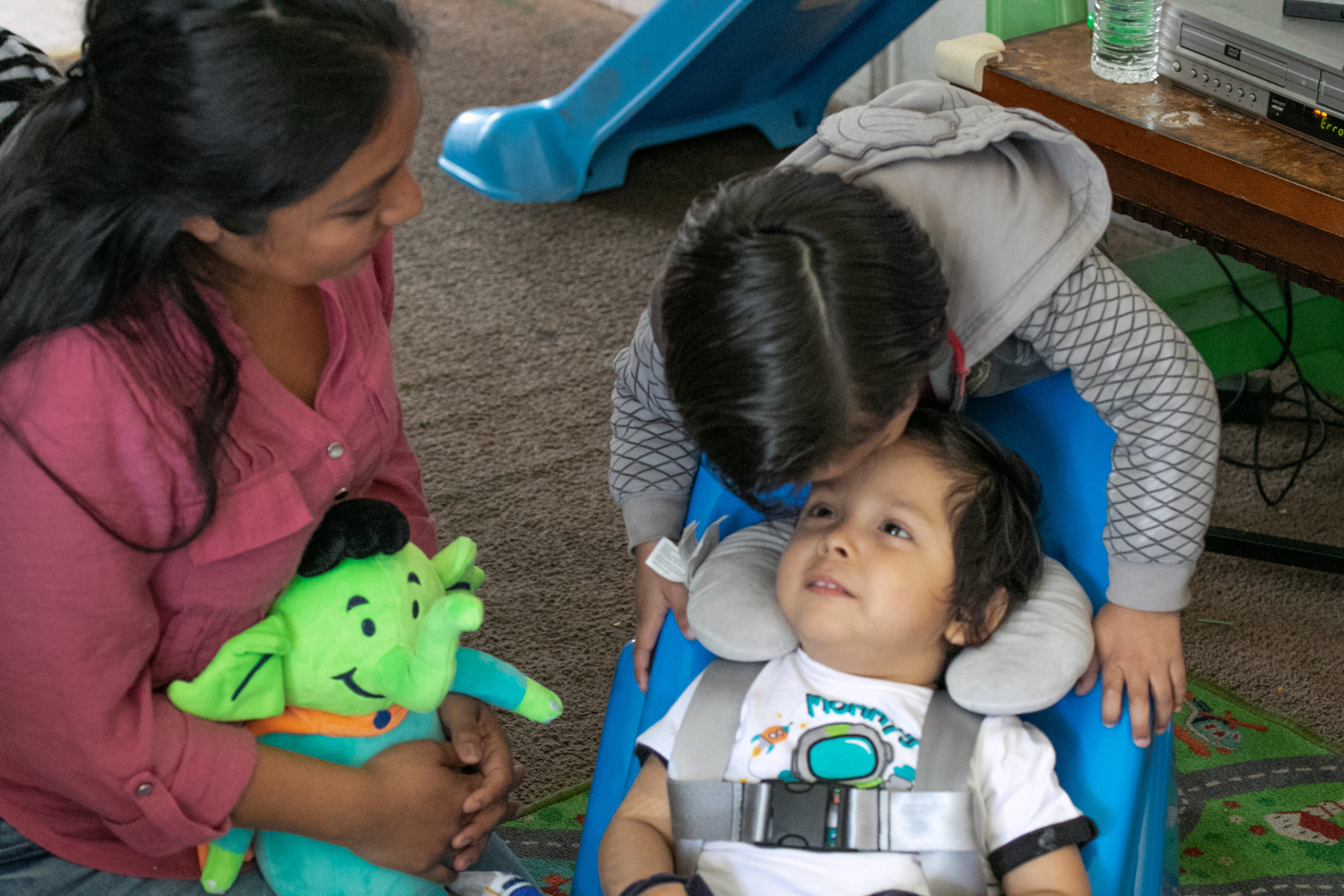 Matthew’s mother Ana looks on as her son Max gives his little brother a kiss on the forehead while seated in the new Tumbleforms chair.