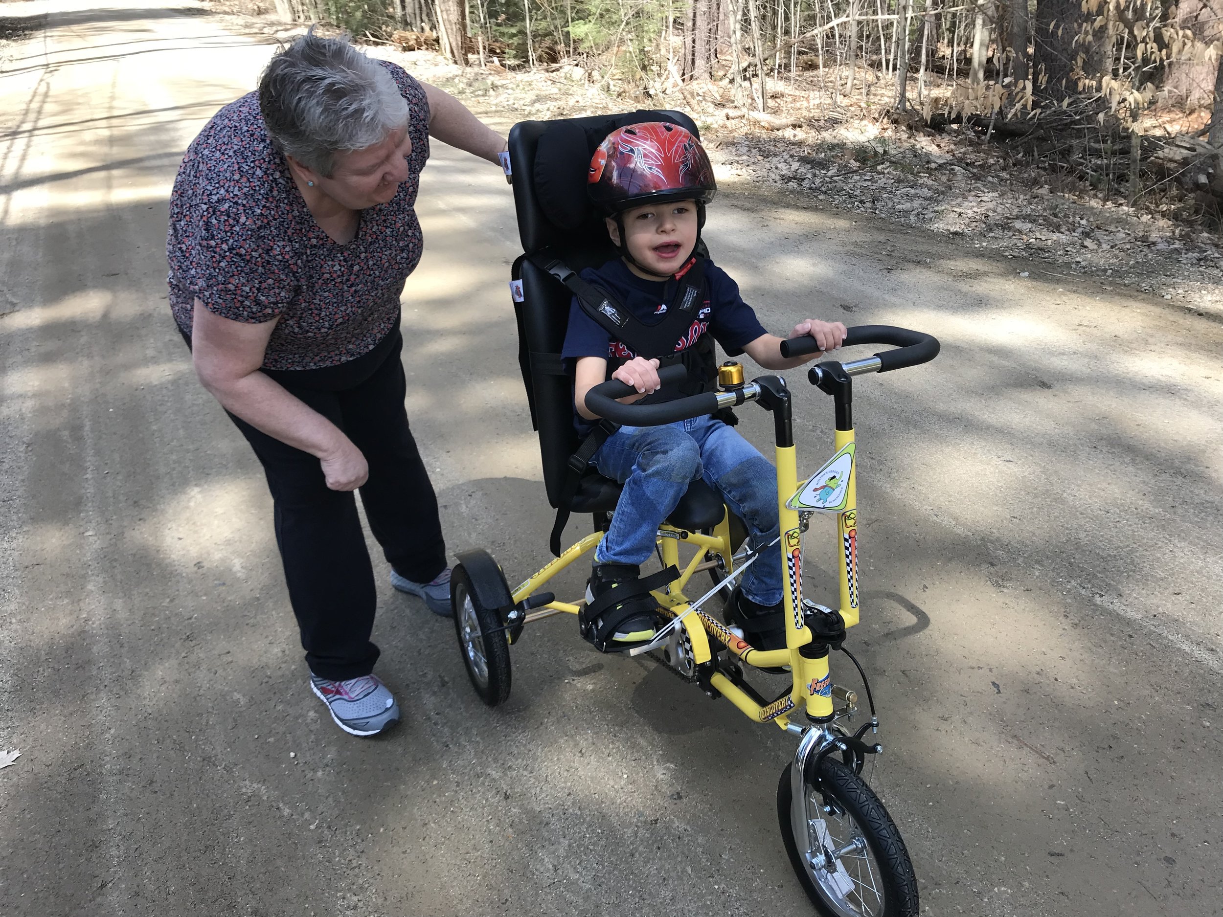 Laurie cheers on Noah as he peddles his new Freedom Concepts bike