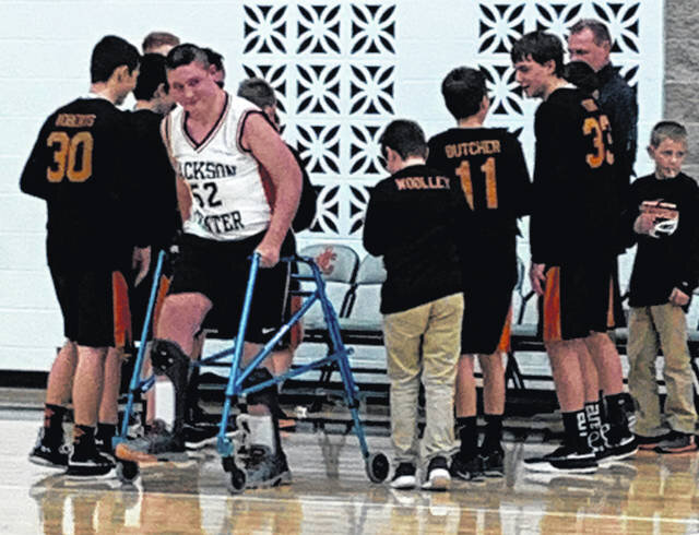 Landon Reese, in white, with teammates during the Jackson Center Tigers’ final regular season basketball game of his eighth-grade year on Jan. 28. Reese was seriously injured after he was kicked in the head by a horse in 2012 and regularly works to 