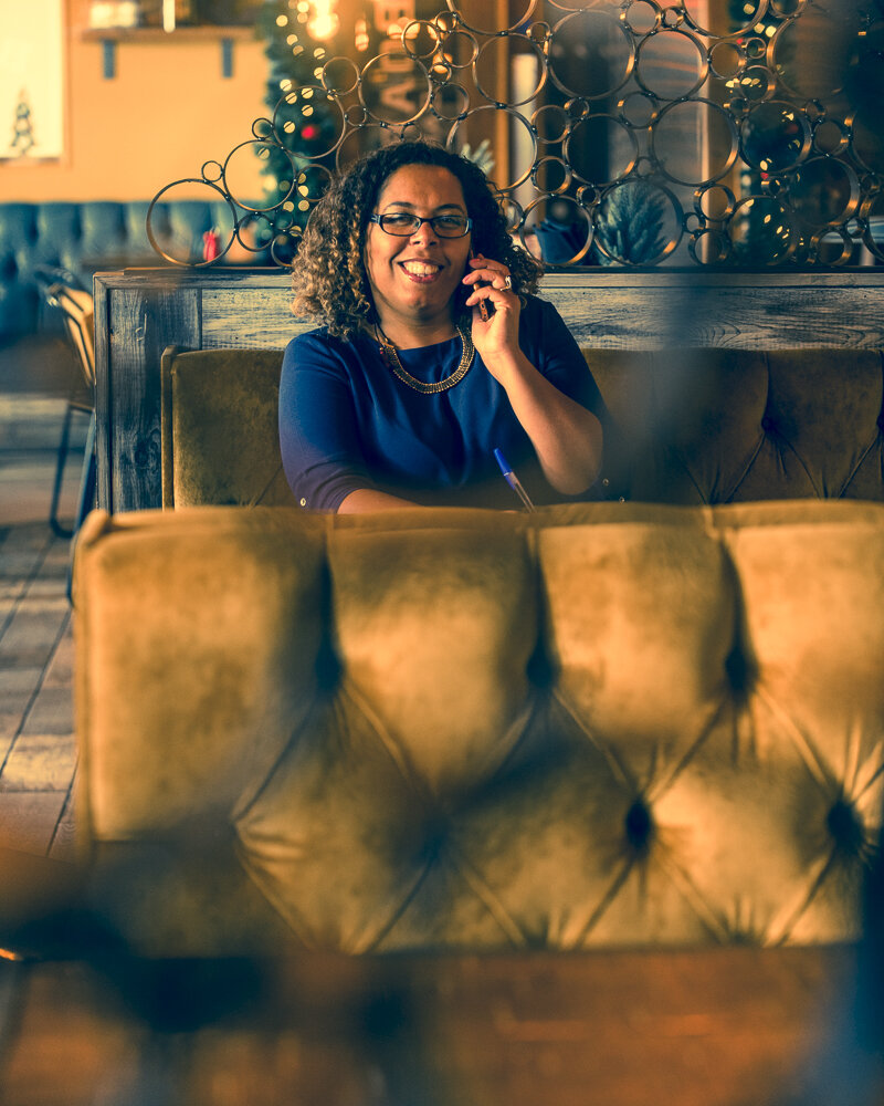 Business woman sitting in booth speaking on her phone, PR Coach, PR Expert