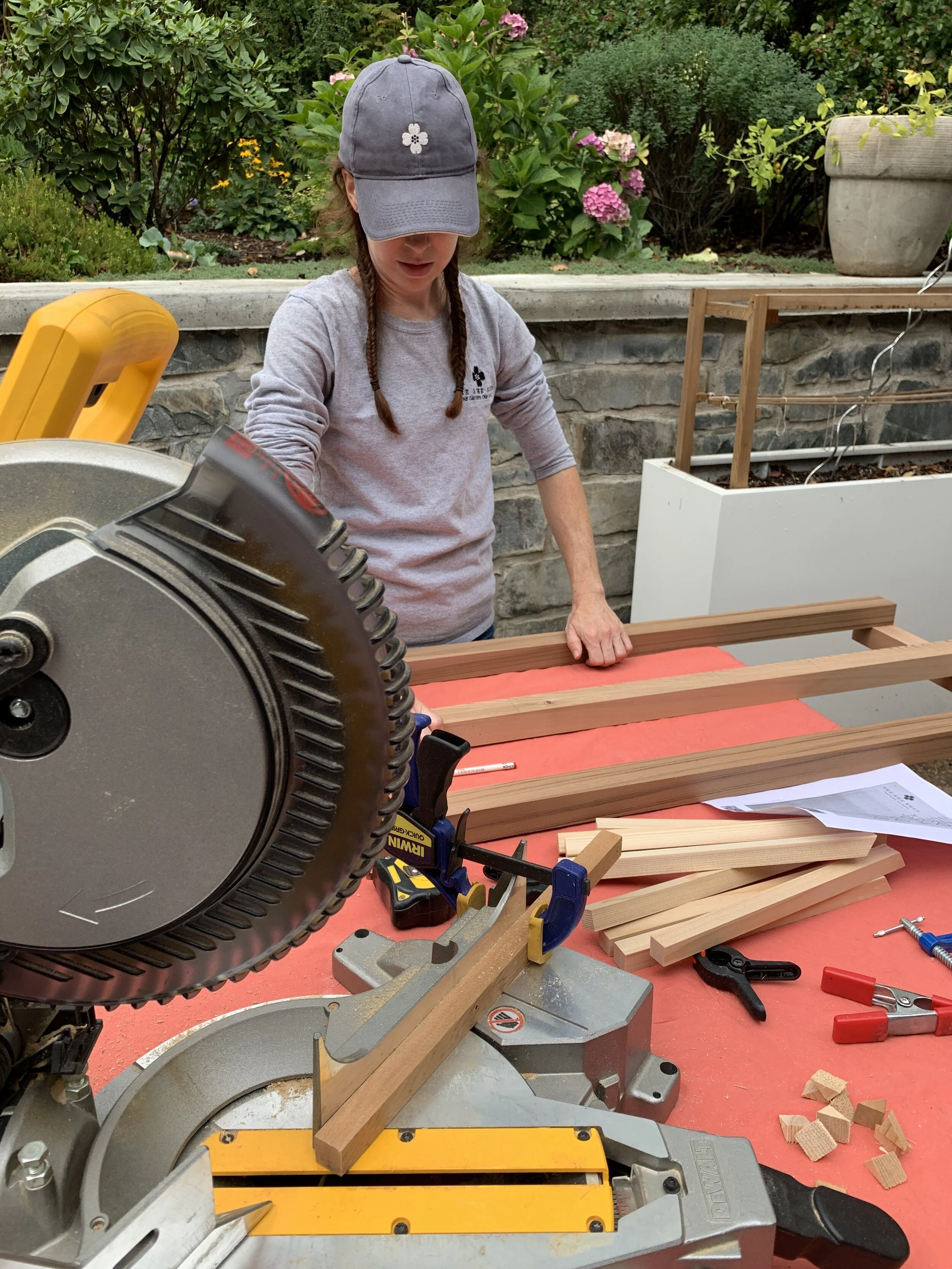 The existing trellises were broken from the weight of the existing climbing roses…and removed.   Amy’s design included the construction of a custom, cedar trellis to extend up both sides and across the top of a feature exterior wall. Over time, the