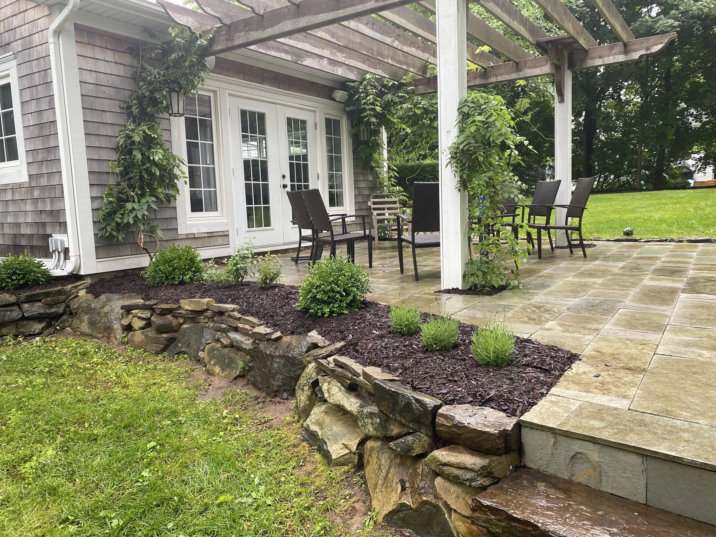  The courtyard and shed garden beds were updated with Blue Moon wisteria, pink peony, lavender and more classic boxwood and hydrangeas to bring cohesion and harmony across the garden. 