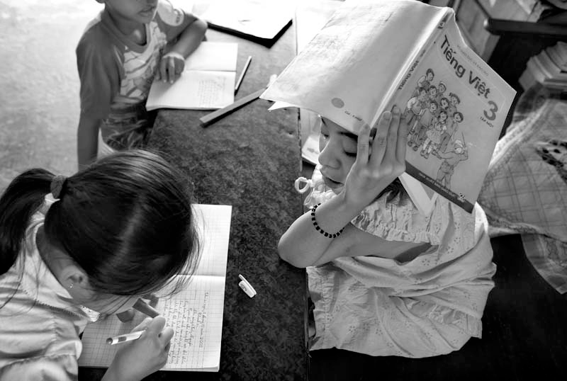 Thao tutoring local children from the village in her library.