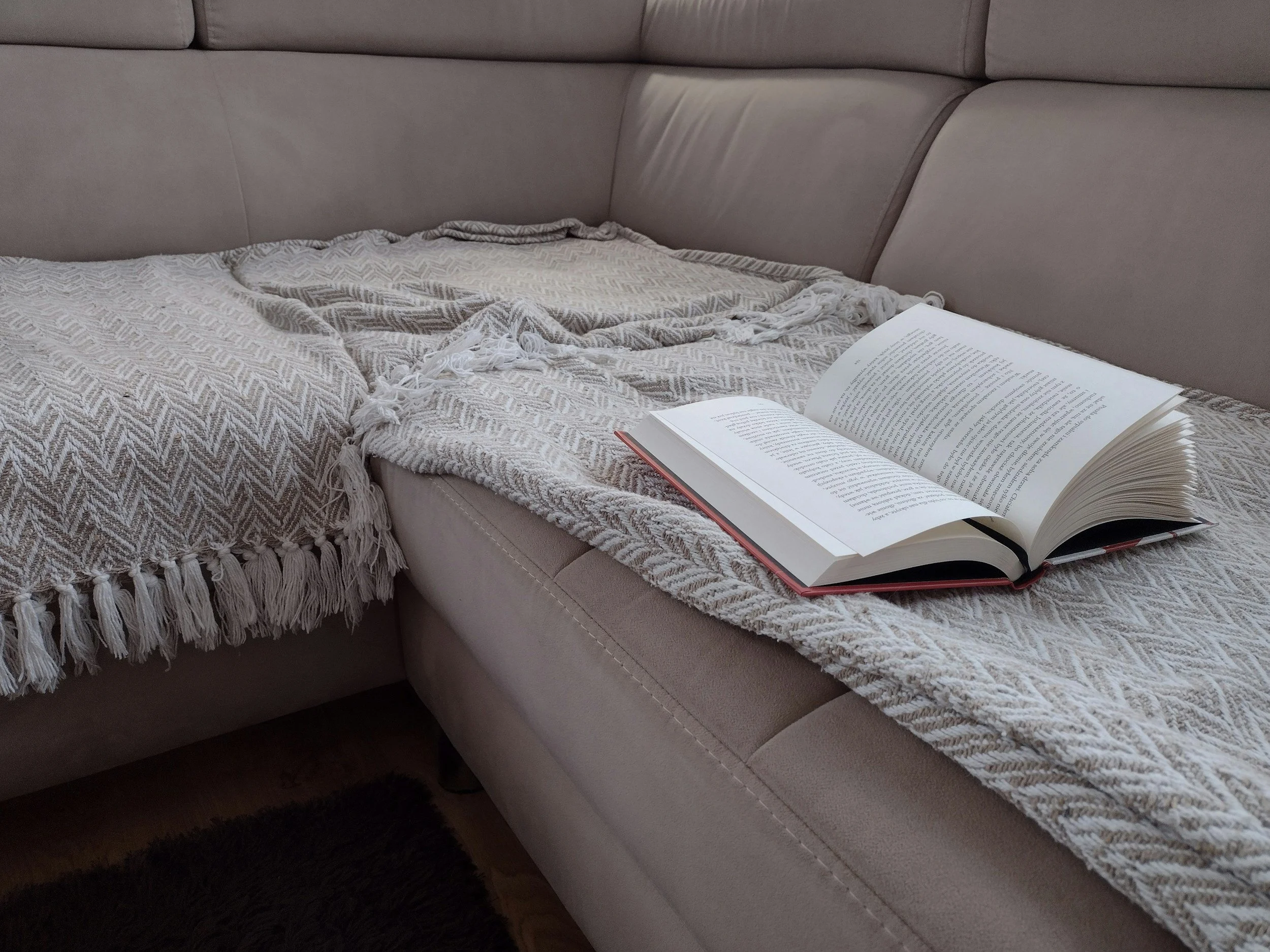 calm minimalist UK home interior with blanket drapped over sofa.  Titled: After the Holiday: Rest, Recovery, and Self-Compassion with ME/CFS