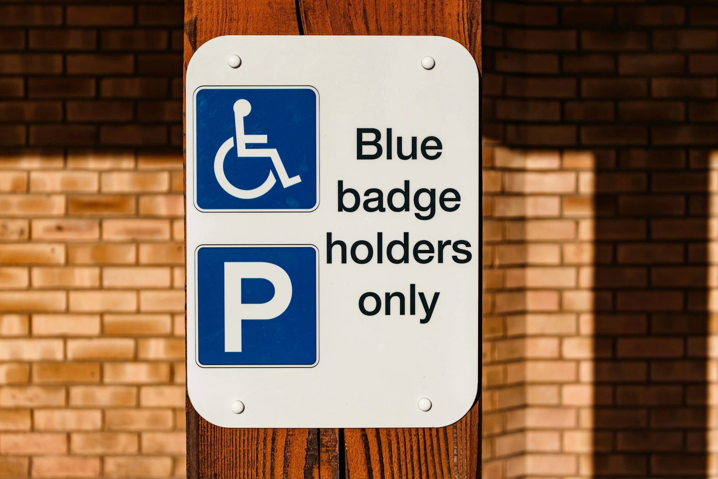 Blue Badge displayed inside a car in a disabled parking space in the UK