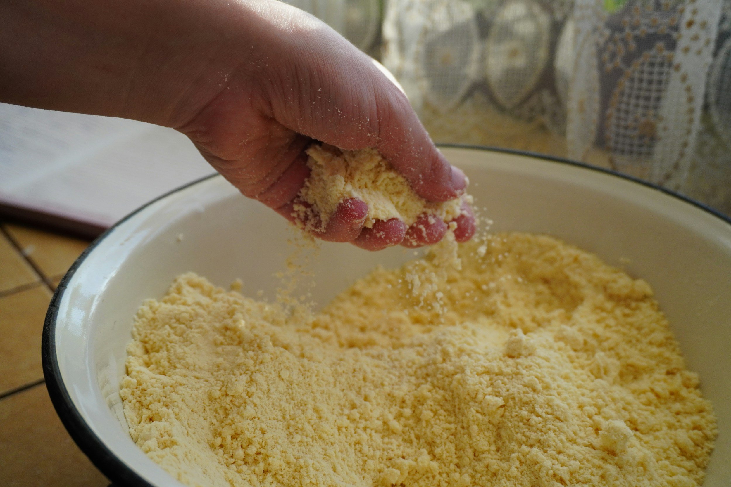 A women's hand in a large bowl of flour