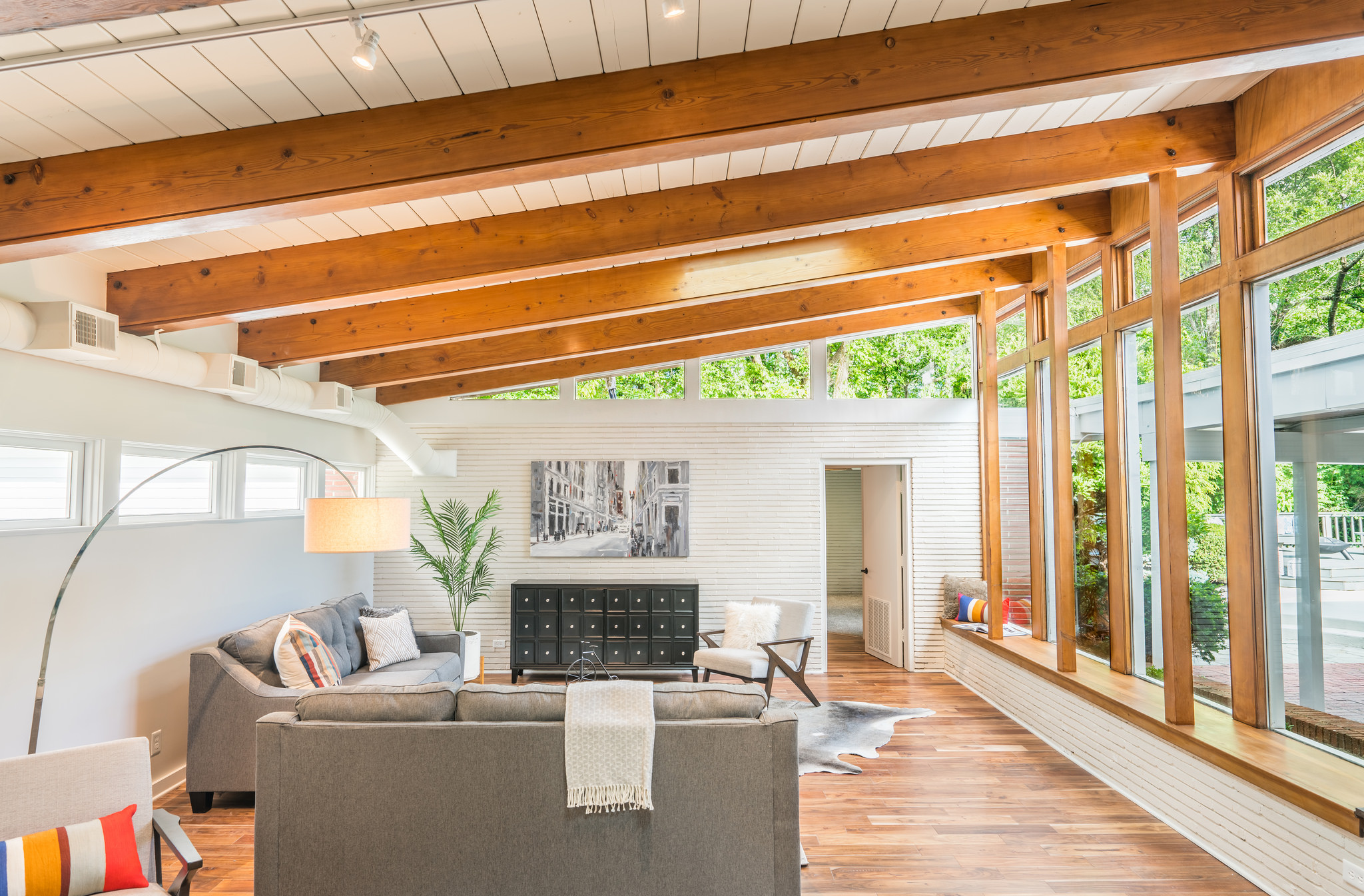 Living room with tall windows looking out onto pool deck