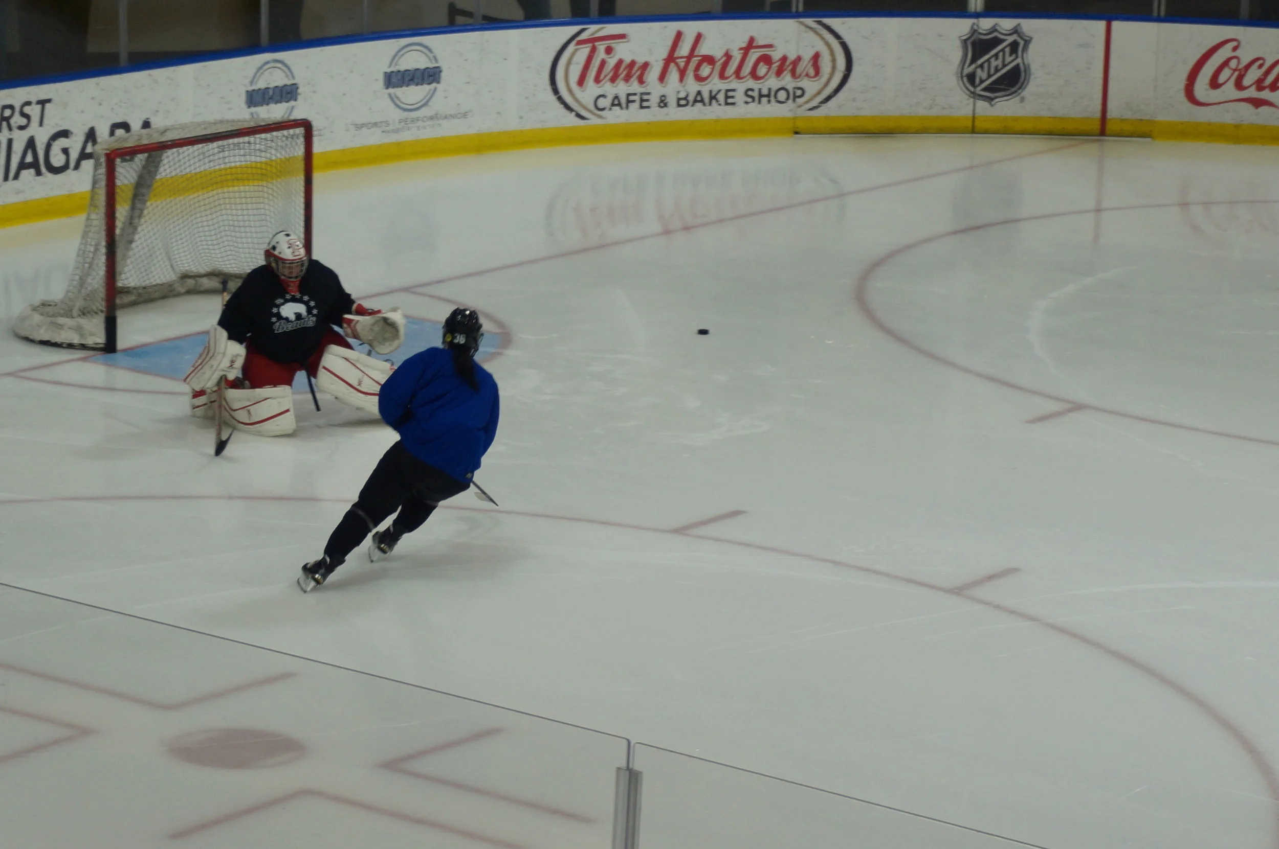Neumann tracks the puck after a save on Kourtney Kunichika