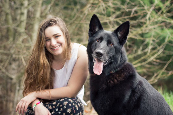  Person and black dog at eye level in a park. 