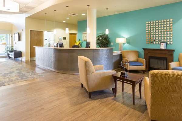 Brightly lit reception area with green wall and gold furniture