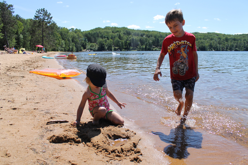 The public beach at Papineau Lake is popular with young families because of its sandy beach and shallow water.