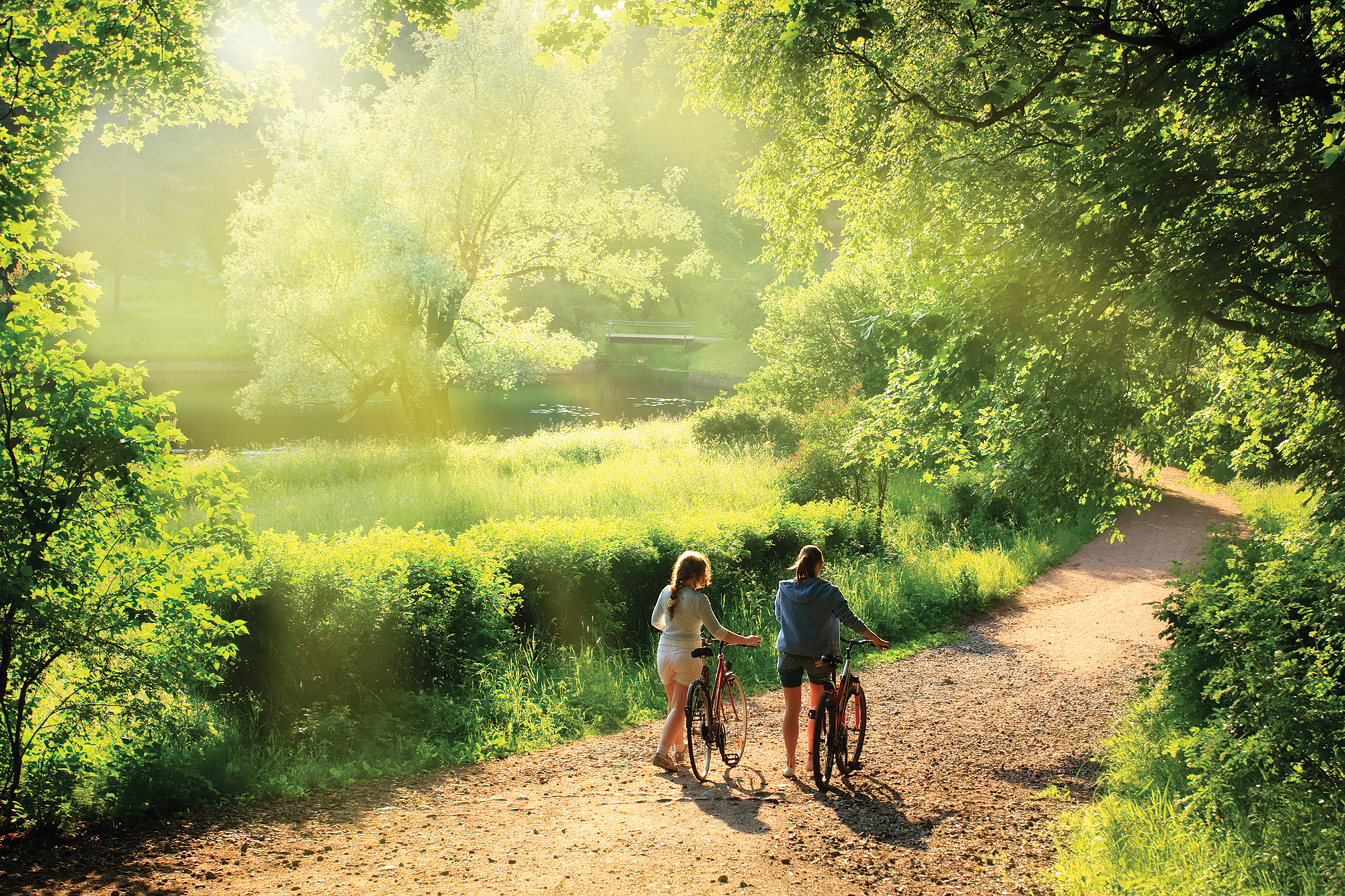 Taking a break from cycling, two children reconnect with nature as they walk along the trail. Photo courtesy Eastern Ontario Trails Alliance.