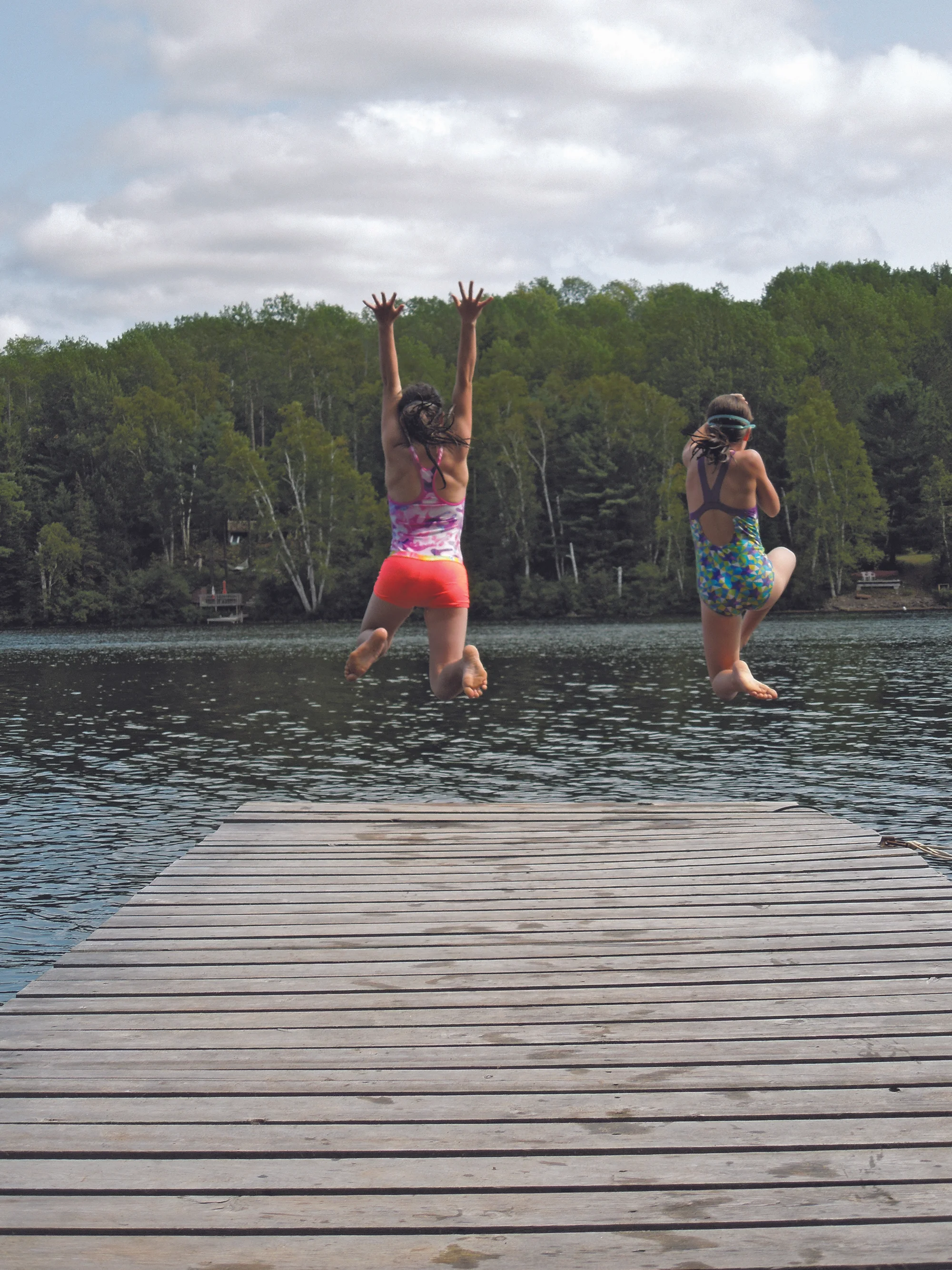 2ND PLACE – SUMMER SISTERS Photographer: Heather Cowley Photo Description: Sisters Sylvie and Kaelan were caught in this photo leaping off the dock into Lake St. Peter, Ontario.