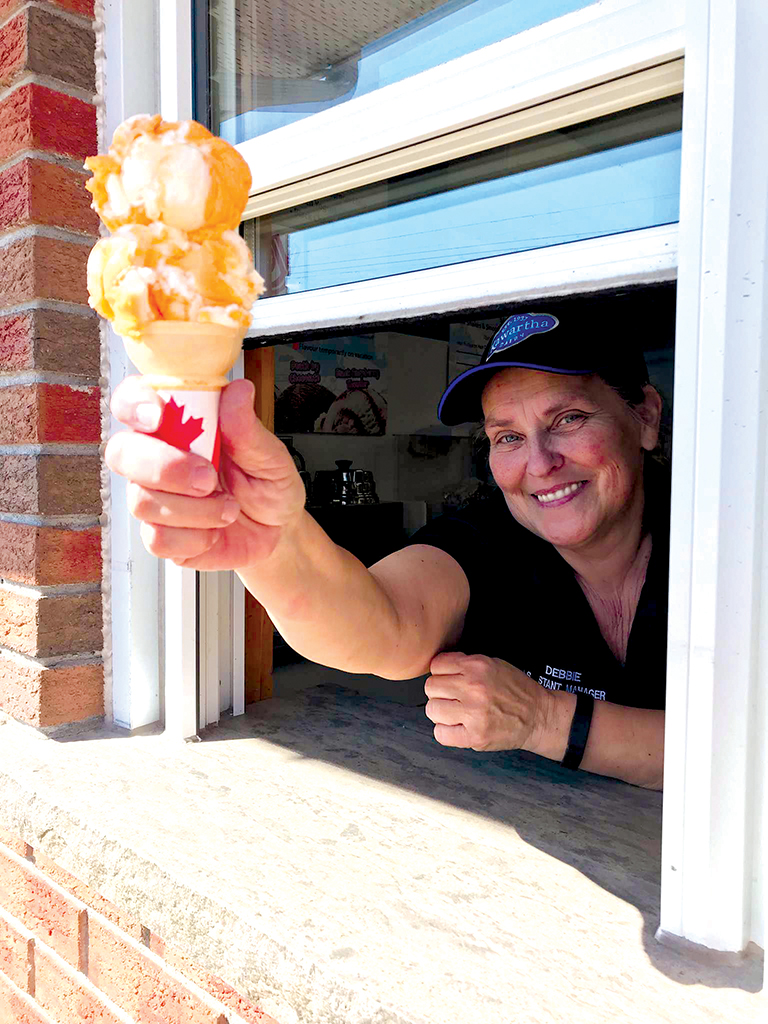 Debbie is expert at dishing out the “scoop”. Shown here with a cone of Tiger Tail ice cream, just one of the delicious flavours associated with summer vacations. Photo by James Kerr.
