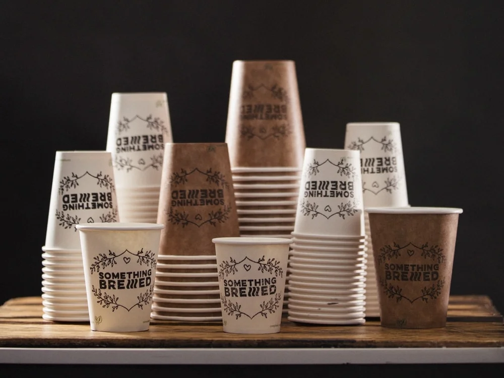 A selection of Vegware Cups in 3 different sizes and 2 colours with "Something Brewed" stamp