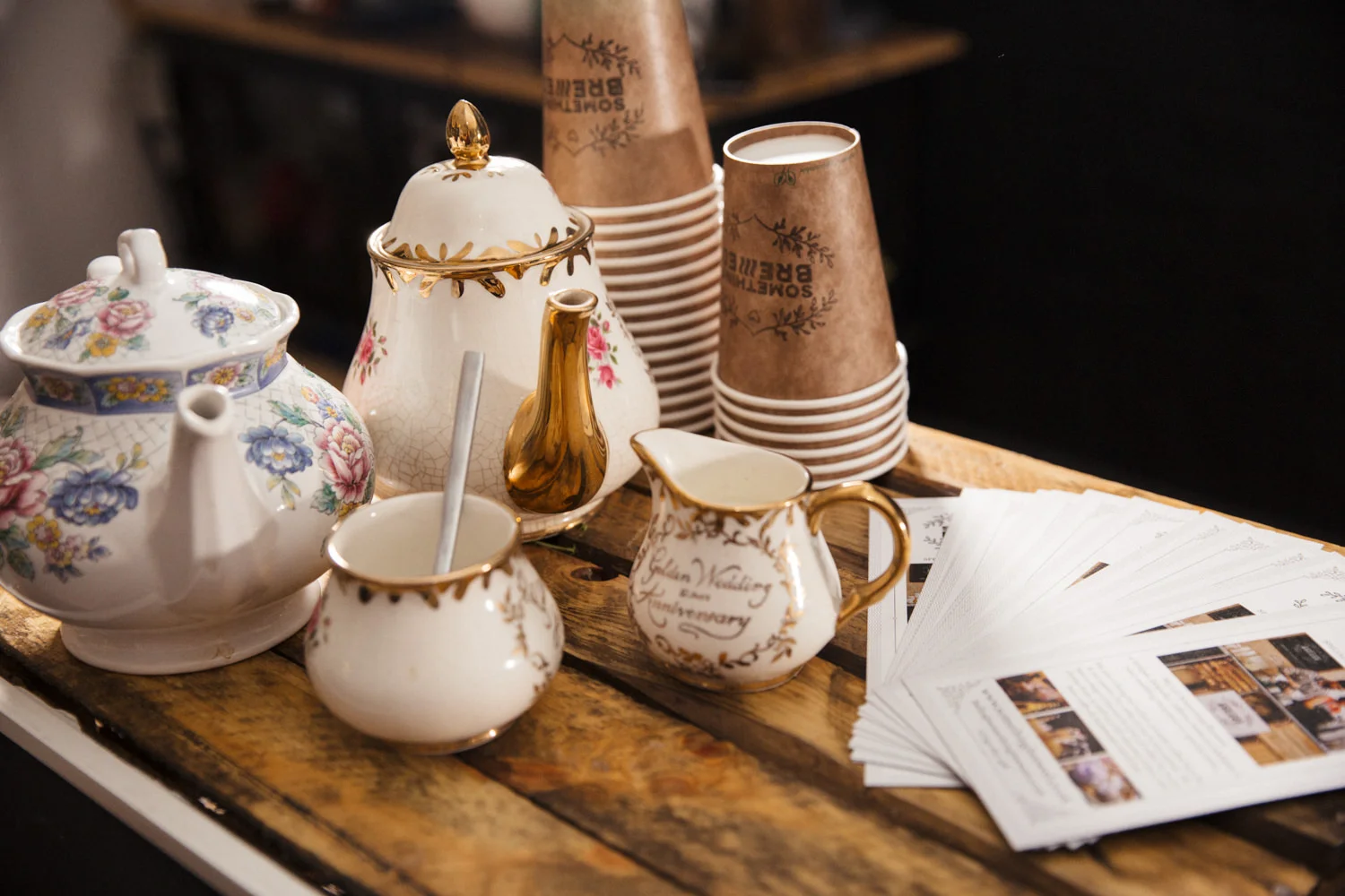 Tea Stand set up including vintage teapots, milk jugs, sugar pot and brown paper cups on our vintage coffee bar for hire in Scotland