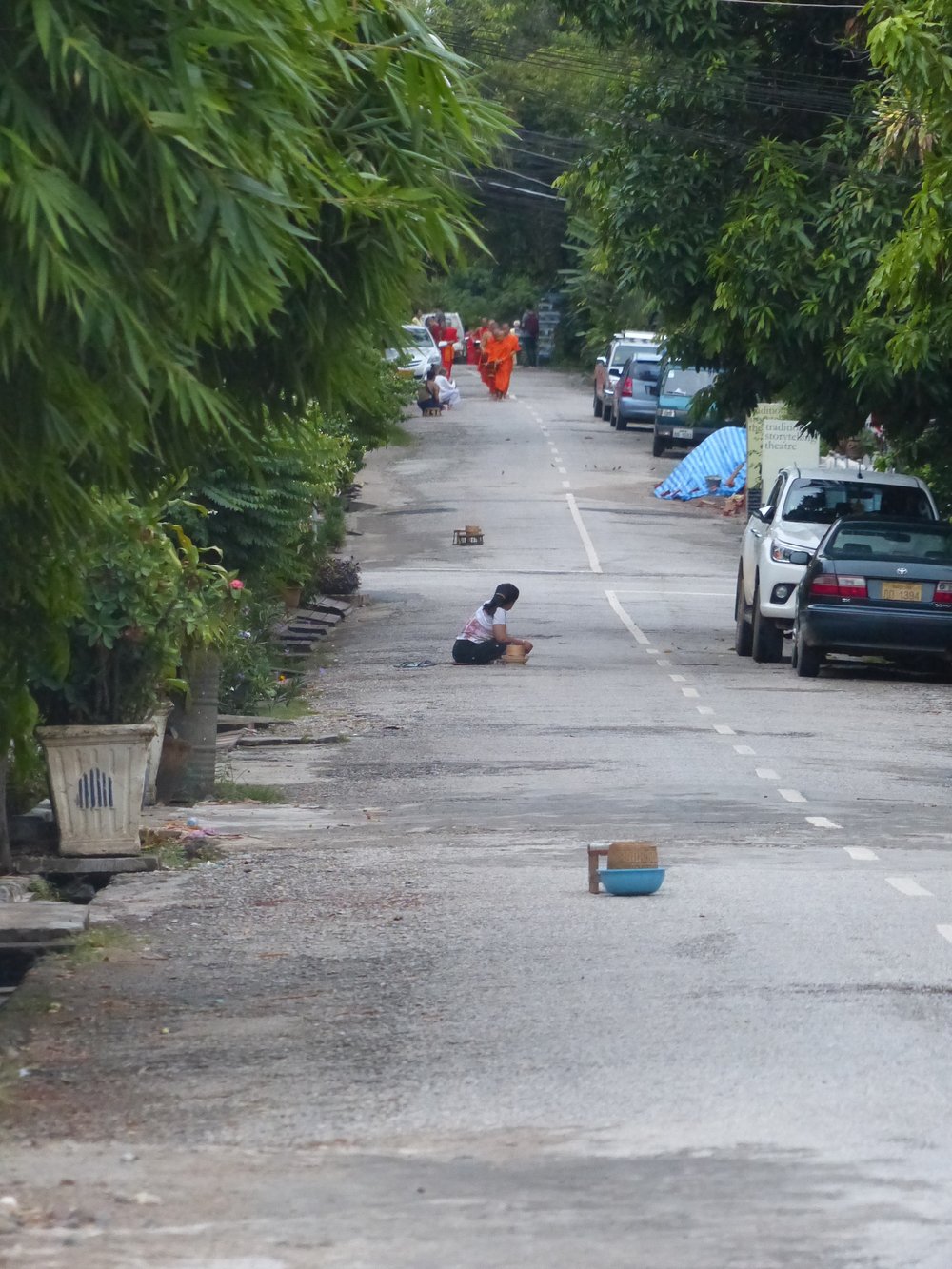 Monks arriving in the distance for alms