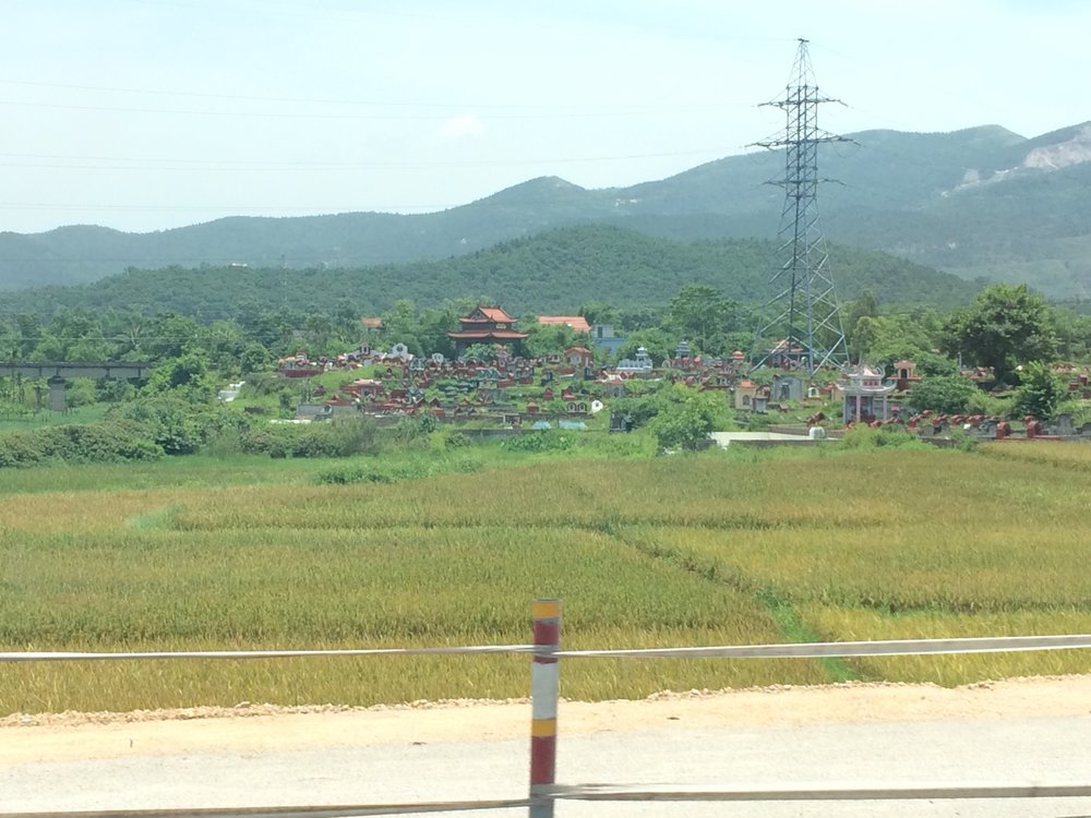 Why are graveyards in the Vietnamese countryside on slight hilltops?