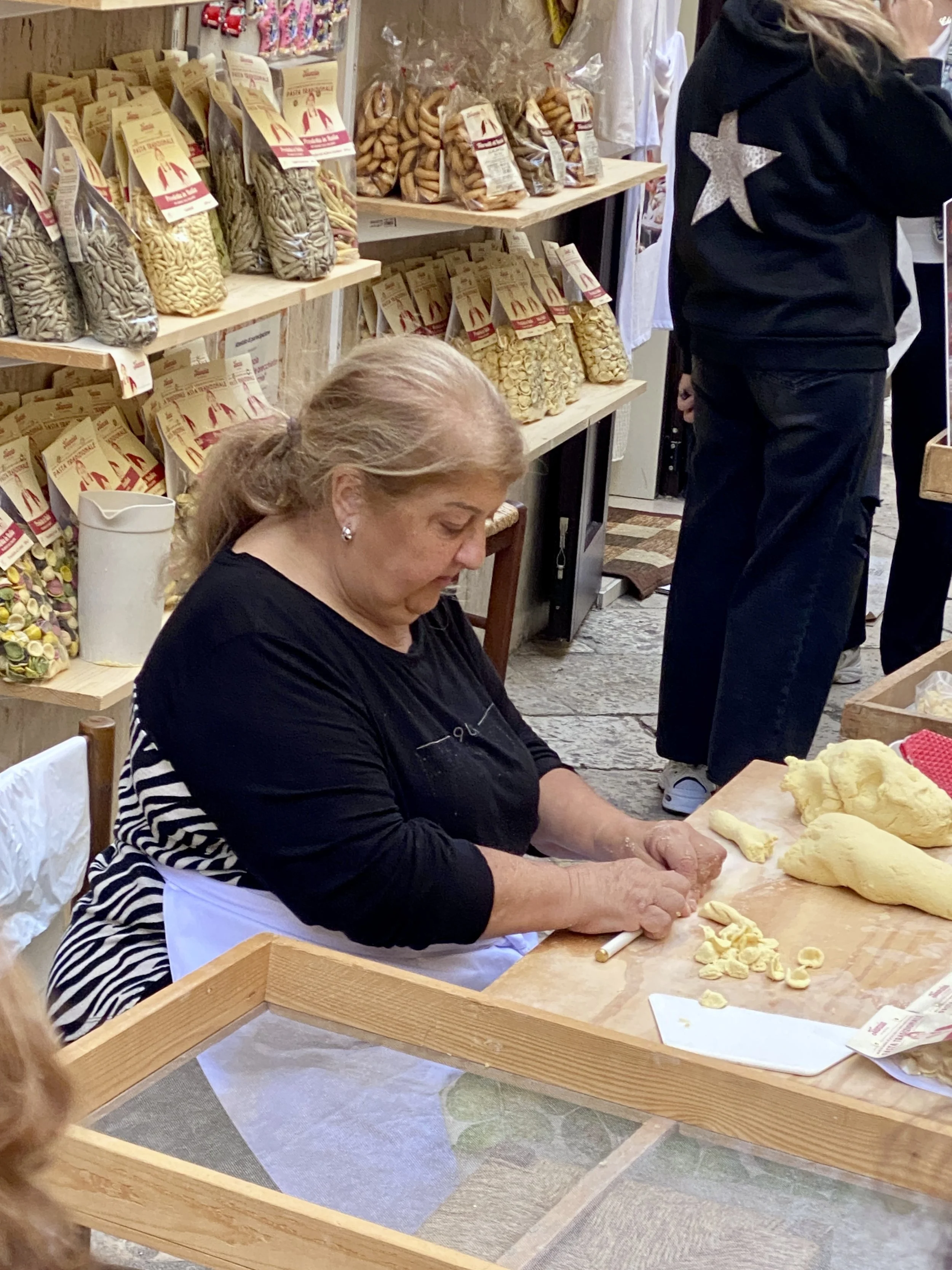 woman rolling pasta on Strada delle Orecchiette  in Bari, Italy